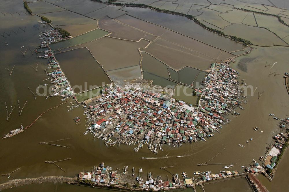 Lingayen from the bird's eye view: Blick auf ein Fischerdorf am Fluss. Die Fischer leben oftmals mit ihren Familien in ärmlichen Hütten aus Blech. View on a fishing village. Often, the fisher live with their families in corrugated-iron huts.