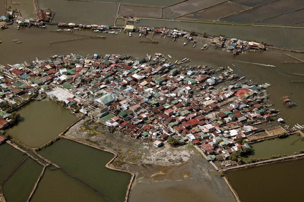 Lingayen from above - Blick auf ein Fischerdorf am Fluss. Die Fischer leben oftmals mit ihren Familien in ärmlichen Hütten aus Blech. View on a fishing village. Often, the fisher live with their families in corrugated-iron huts.