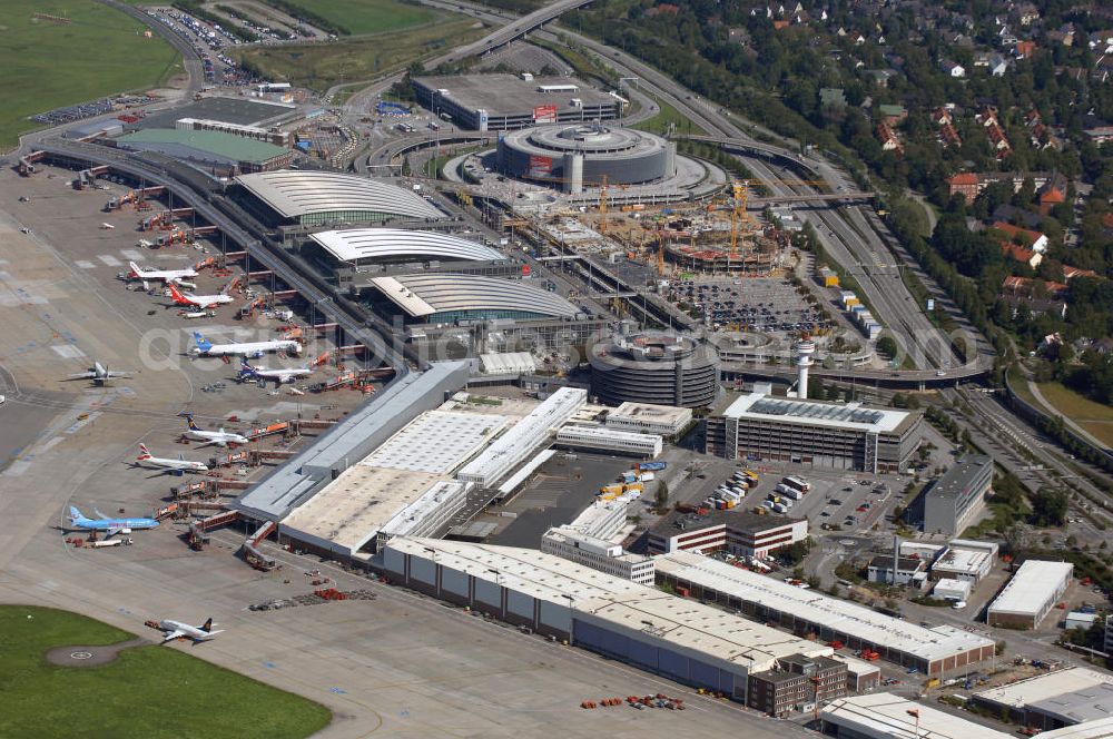 Hamburg from the bird's eye view: Blick auf den Flughafen Hamburg im Stadtteil Fuhlsbüttel. Der internationale Flughafen ist der fünftgrößte und älteste Flughafen Deutschlands und zählt zu den modernsten Flughäfen Europas. Im Jahr 1912 wurde der Hamburg Airport, den Beinamen erhielt der Flughafen 1945 durch die Britische Besatzungsmacht, eröffnet. Er erstreckt sich auf einer Fläche von 570ha, hat 2 Terminals und befördert ca. 16 Millionen Passagiere jährlich. Betreiber des Hamburger Flughafens ist die Flughafen Hamburg GmbH, die zu 51 Prozent der Freien und Hansestadt Hamburg und zu 49 Prozent der Hochtief AirPort gehört. Letztere ist eine Tochtergesellschaft des internationalen Baudienstleisters Hochtief. Kontakt: Flughafen Hamburg GmbH, Flughafenstraße 1-3 22335 Hamburg, Tel. +49(0)40 5075 0, Fax +49(0)405075 1234