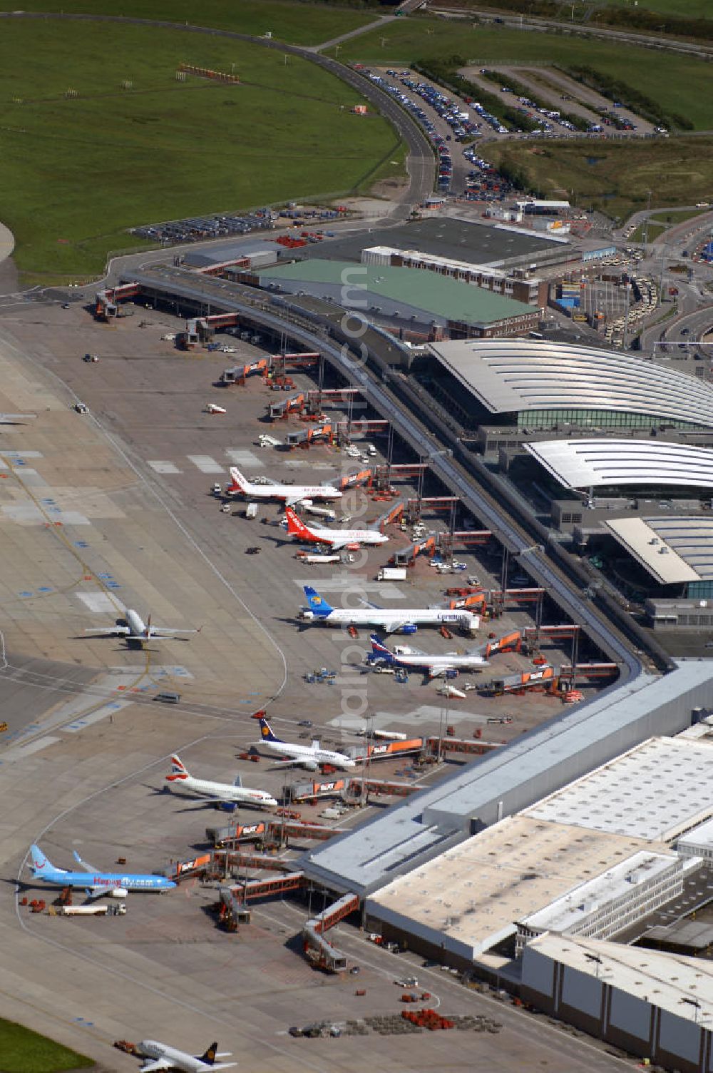 Aerial image Hamburg - Blick auf den Flughafen Hamburg im Stadtteil Fuhlsbüttel. Der internationale Flughafen ist der fünftgrößte und älteste Flughafen Deutschlands und zählt zu den modernsten Flughäfen Europas. Im Jahr 1912 wurde der Hamburg Airport, den Beinamen erhielt der Flughafen 1945 durch die Britische Besatzungsmacht, eröffnet. Er erstreckt sich auf einer Fläche von 570ha, hat 2 Terminals und befördert ca. 16 Millionen Passagiere jährlich. Betreiber des Hamburger Flughafens ist die Flughafen Hamburg GmbH, die zu 51 Prozent der Freien und Hansestadt Hamburg und zu 49 Prozent der Hochtief AirPort gehört. Letztere ist eine Tochtergesellschaft des internationalen Baudienstleisters Hochtief. Kontakt: Flughafen Hamburg GmbH, Flughafenstraße 1-3 22335 Hamburg, Tel. +49(0)40 5075 0, Fax +49(0)405075 1234