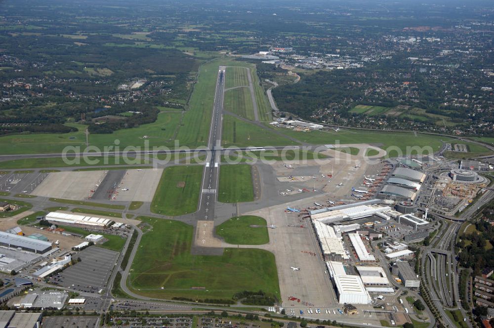 Aerial photograph Hamburg - Blick auf den Flughafen Hamburg im Stadtteil Fuhlsbüttel. Der internationale Flughafen ist der fünftgrößte und älteste Flughafen Deutschlands und zählt zu den modernsten Flughäfen Europas. Im Jahr 1912 wurde der Hamburg Airport, den Beinamen erhielt der Flughafen 1945 durch die Britische Besatzungsmacht, eröffnet. Er erstreckt sich auf einer Fläche von 570ha, hat 2 Terminals und befördert ca. 16 Millionen Passagiere jährlich. Betreiber des Hamburger Flughafens ist die Flughafen Hamburg GmbH, die zu 51 Prozent der Freien und Hansestadt Hamburg und zu 49 Prozent der Hochtief AirPort gehört. Letztere ist eine Tochtergesellschaft des internationalen Baudienstleisters Hochtief. Kontakt: Flughafen Hamburg GmbH, Flughafenstraße 1-3 22335 Hamburg, Tel. +49(0)40 5075 0, Fax +49(0)405075 1234