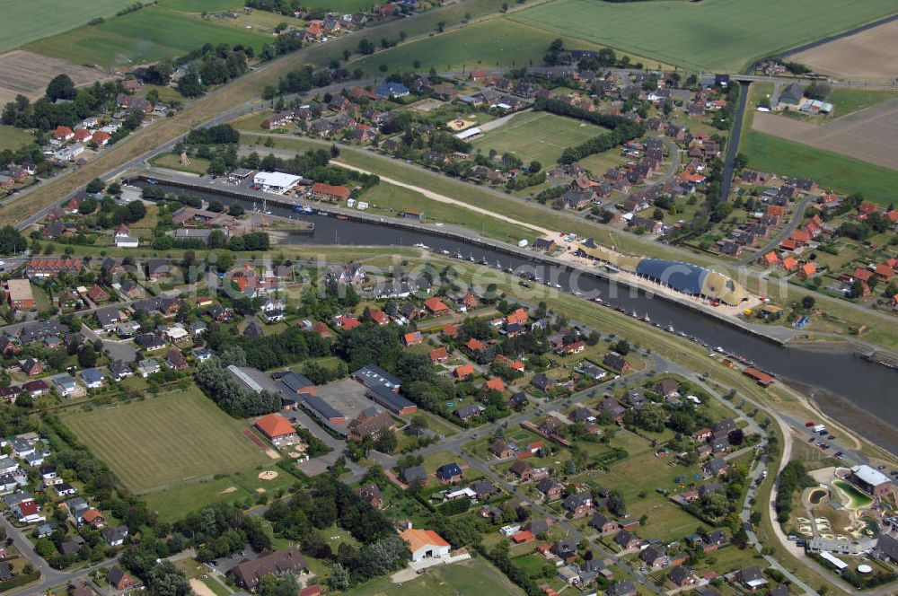 Friedrichskoog from the bird's eye view: Blick auf Friedrichskoog mit Hafen und Baustelle. Friedrichskoog ist eine Gemeinde im Südwesten des Kreis Dithmarschen zwischen der offenen Nordsee und der Elbmündung. Ursprünglich durch Landwirtschaft geprägt kam Anfang des 20. Jahrhunderts die Fischerei hinzu, mittlerweile ist es vor allem ein Touristenort. Die Stadt hat ca. 2400 Einwohner und ist bekannt für ihre Seehundstation. Der Friedrichskooger Hafen wurde 1853-1854 gebaut. Damals wie heute dient er vor allem als Hafen für Fisch und Krabben. In der Nähe entsteht zur Zeit eine Indoorspielhalle in Form eines Wal. Kontakt: Tourismus-Service Friedrichskoog, Koogstraße 141, 25718 Friedrichskoog, Tel. +49 (0)4854 90494 0, Fax +49 (0)4854 90494 19, EMail info@friedrichskoog.de