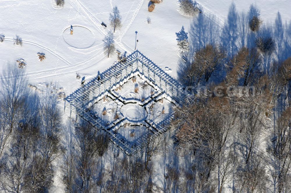 Berlin from the bird's eye view: Blick auf den Garten des wiedergewonnenen Mondes im winterlich verschneiten Chinesischen Garten im Erholungspark Marzahn. Der Erholungspark Marzahn liegt im Berliner Bezirk Marzahn-Hellersdorf am nördlichen Fuß des Kienbergs und wurde am 9. Mai 1987 anlässlich der 750-Jahr-Feier von Berlin als Berliner Gartenschau und Geschenk der Gärtner an die Hauptstadt der DDR (Ost-Berlin) eröffnet und sollte somit ein Gegenstück zum Britzer Garten im damaligen West-Berlin darstellen. 1991 wurde die Berliner Gartenschau nicht nur in Erholungspark Marzahn umbenannt, sondern auch umgebaut: Große Spiel- und Liegewiesen sowie neue Spielplätze entstanden, Bäume wurden gepflanzt und Sondergärten überarbeitet und erweitert. Der neu gestaltete Park sollte den 300.000 Bewohnern der umliegenden Großsiedlungen als vielfältig nutzbare Erholungslandschaft dienen. Seit Oktober 2000 ist diese durch ihre Gärten der Welt auch weit über die Stadtgrenzen hinaus bekannt. 2005 wurde der Chinesische Garten im Erholungspark Marzahn als drittschönste Parkanlage Deutschlands ausgezeichnet. Außerdem gehört der Erholungspark zu den 365 Orten im Land der Ideen.