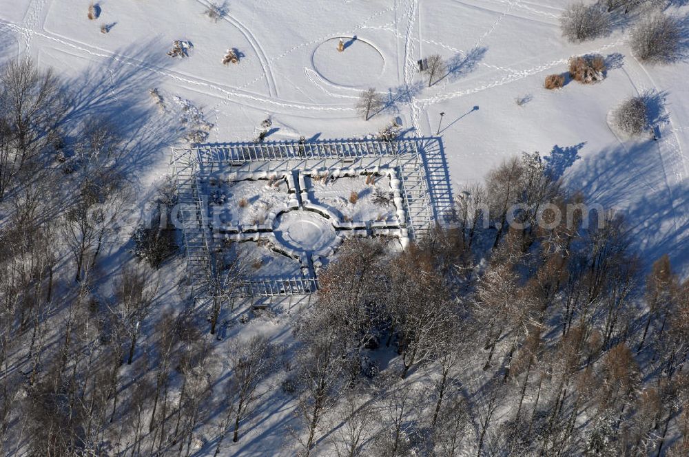 Berlin from above - Blick auf den Garten des wiedergewonnenen Mondes im winterlich verschneiten Chinesischen Garten im Erholungspark Marzahn. Der Erholungspark Marzahn liegt im Berliner Bezirk Marzahn-Hellersdorf am nördlichen Fuß des Kienbergs und wurde am 9. Mai 1987 anlässlich der 750-Jahr-Feier von Berlin als Berliner Gartenschau und Geschenk der Gärtner an die Hauptstadt der DDR (Ost-Berlin) eröffnet und sollte somit ein Gegenstück zum Britzer Garten im damaligen West-Berlin darstellen. 1991 wurde die Berliner Gartenschau nicht nur in Erholungspark Marzahn umbenannt, sondern auch umgebaut: Große Spiel- und Liegewiesen sowie neue Spielplätze entstanden, Bäume wurden gepflanzt und Sondergärten überarbeitet und erweitert. Der neu gestaltete Park sollte den 300.000 Bewohnern der umliegenden Großsiedlungen als vielfältig nutzbare Erholungslandschaft dienen. Seit Oktober 2000 ist diese durch ihre Gärten der Welt auch weit über die Stadtgrenzen hinaus bekannt. 2005 wurde der Chinesische Garten im Erholungspark Marzahn als drittschönste Parkanlage Deutschlands ausgezeichnet. Außerdem gehört der Erholungspark zu den 365 Orten im Land der Ideen.