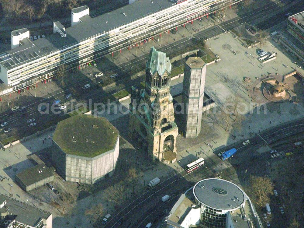 Berlin from the bird's eye view: 07.02.2005, Blick auf die Gedächtniskirche in Berlin Charlottenburg, Breitscheidplatz / Kurfürstendamm, Berlin (Charlottenburg),Im Zweiten Weltkrieg wurde die Kirche stark zerstört und steht seitdem als Mahnmal, für die sinnlose Zerstörung des Krieges. Umgeben ist der hohle Zahn von mehreren architektonisch modernen Gebäuden der Kirche, in denen sich u.a. eine Gedenkhalle befindet. Dieses Nebeneinan der von Alt und Neu soll die Vergangenheit mit der Zukunft verbinden.