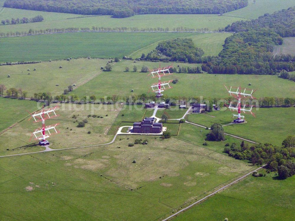 Nauen from above - Blick auf das Gelände der historische Sendestelle Nauen. Von hier wurde schon seit 1906 weltweit gesendet. Uebliche Sendefrequenzen lagen bei 20-100 kHz. Antennenlaenge 2,4 km. Modulation in Morsezeichen. Nauen sendete und empfing u.a. Telegramme. In Geltow bei Potsdam wurde eine Empfangs-Station gebaut (30 km von Nauen entfernt). Hier stoerten die starken Sende-Signale nicht den Funkempfang. In Nauen wurden Knallfunkensender, Loeschfunkensender, Hochfrequenz-Maschinen und Roehrensender eingesetzt. Eine der korrespondierenden Stationen in den USA war Long Island bei New York. 1920 wurde das neue Sende-Gebäude (von Herman Muthesius) eingeweiht. Die Transradio Gesellschaft fuehrte weltweiten Funkbetrieb durch. Gesendet wurde Hochgeschwindigkeits-Morse- Code. Telegramme konnten auch in Bueros in Berlin und an deren Staedten aufgegeben werden. Auch Zeitzeichen wurden gesendet. Ab 1940 wurde auch Rundfunk gesendet. Ab 1957 sendete aus benachbarten Gebaeuden Radio Berlin International, Deutscher demokratischer Rundfunk. Seit 1990 ist die Deutsche Welle aktiv. 1997 wurden 4 neue KW-Sender mit jeweils 500 kW in Betrieb genommen. Sender und Antenne bilden eine Einheit (Foto eines der vier Senderaeume ). Die alten KW-Sender aus DDR-Zeit sind noch im Reserve-Betrieb. Die alte Dreh-Antenne war weltweit bekannt. Ein Teil der alten Antennen-Anlage ist 1999 abgerissen worden.