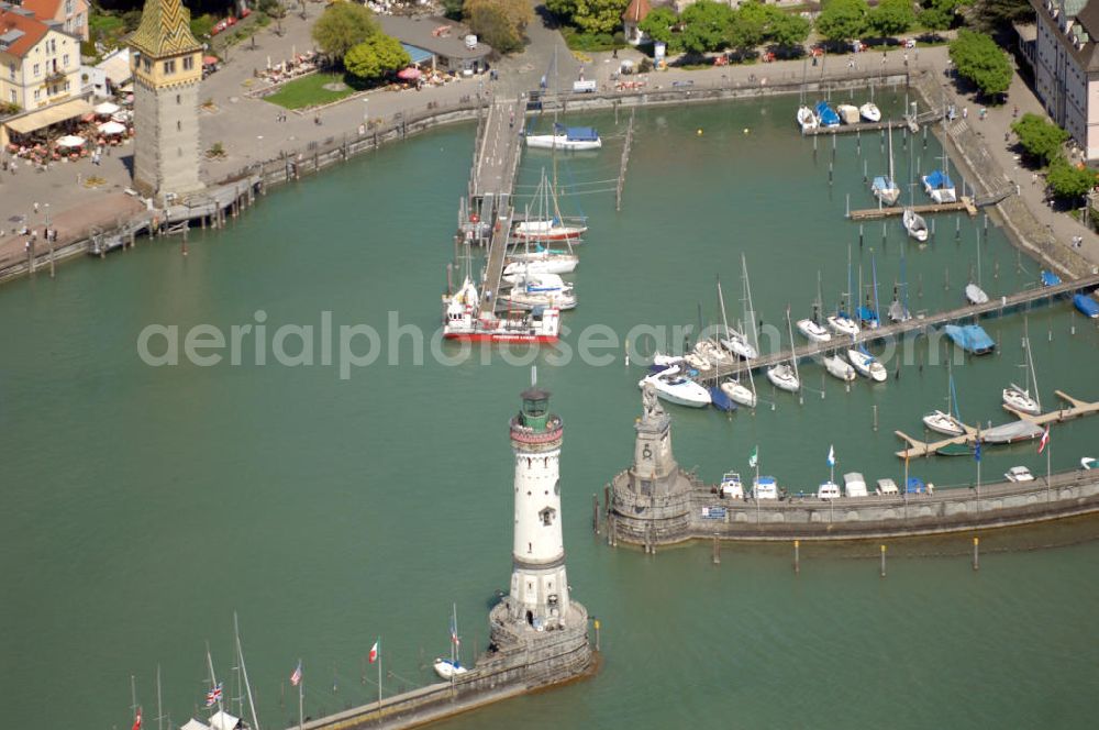 Lindau from the bird's eye view: Blick auf die Hafeneinfahrt der Lindau Insel am Bodensee. Die Hafeneinfahrt an der Lindau Insel ist von einem Leuchtturm und dem Bayerischen Löwen begrenzt. Der Mangturm wurde um 1200 als Leuchtturm erbaut und war der Turm der ehemaligen Stadtbefestigung. Als besonderer Hingucker dient hier das bunte Dach, welches aus dem 19. Jhd. stammt. Seinen Namen hat er durch das ehemalige Tuch- und Manghaus, dass sich dort in der Nähe befand. Kontakt: Tourist-Information, Ludwigstraße 68, 88131 Lindau, Te??????????????????????????????????????????????????????????????????????????