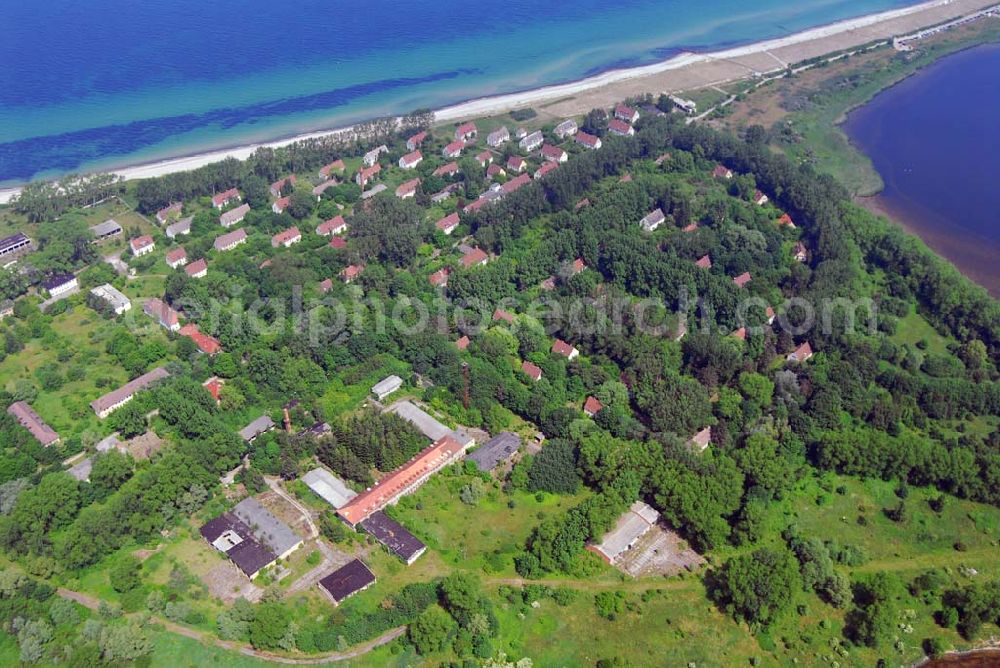 Rerik from the bird's eye view: Blick auf die Halbisel Wustrow - 1273 zum ersten Mal erwähnt, war die Halbinsel bis Anfang der 1930er Jahre ein landwirtschaftliches Gut in den Händen zahlreicher Besitzer. 1933 wurde die Halbinsel Wustrow an die Reichswehr verkauft, welche unverzüglich mit dem Aufbau von Deutschlands größter Flakartillerieschule, der FAS I, begann. Im vorderen Teil der Halbinsel wurde eine Wohnsiedlung und der Militärbautenkomplex mit Flugplatz und Sportanlagen errichtet. Soldaten aus allen Teilen Deutschlands wurden an den Fla-Geschützen in mehrwöchigen Lehrgängen ausgebildet. Nach dem Kriegsende dienten die Wohnungen zunächst Tausenden von Flüchtlingen als Unterkunft, bis die sowjetische Militärführung 1949 alle Deutschen zur Räumung der Halbinsel aufforderte und die Garnison Wustrow etablierte, deren letzte Soldaten und Offiziere im Oktober 1993 offiziell verabschiedet wurden. Die Halbinsel wurde Grundvermögen des Bundes. Nach Meinungsverschiedenheiten zwischen dem Bund und der Stadt Rerik wurde die gesamte Halbinsel schließlich im Februar 1998 an die in Köln ansässige Fundus-Gruppe verkauft.