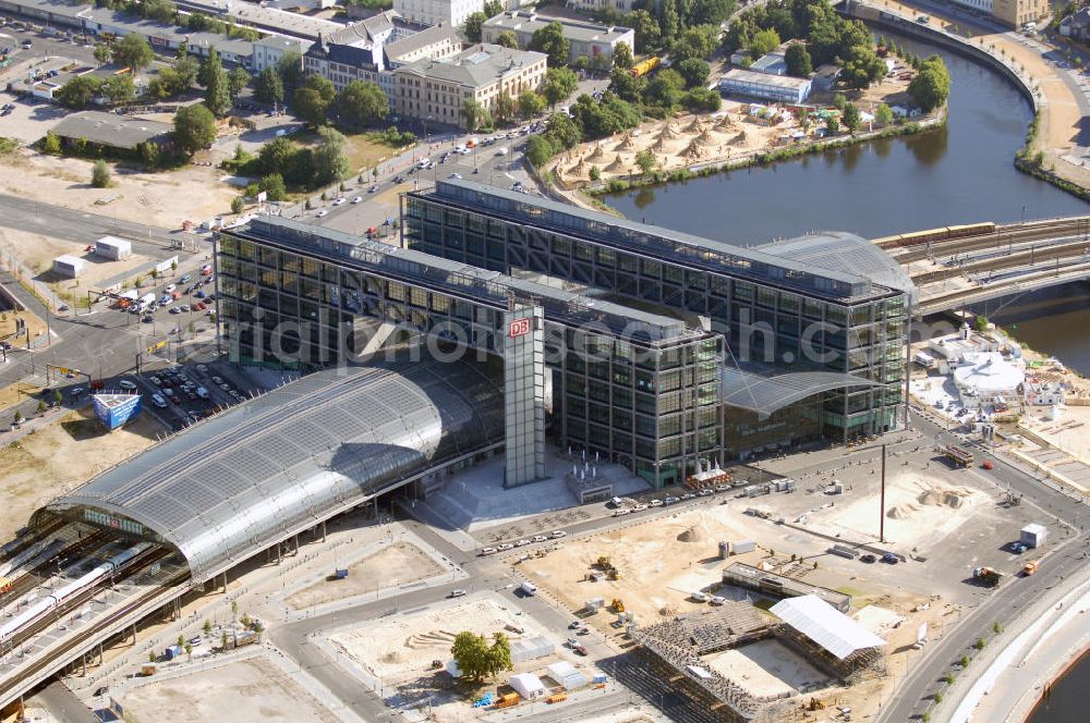 Aerial image Berlin - Berlin Hauptbahnhof ist der Name des Zentralbahnhofs der Stadt Berlin im Ortsteil Moabit des Bezirks Mitte. Der von dem Architekten Meinhard von Gerkan entworfene Etagenbahnhof wurde auf dem Gelände des einstigen Lehrter Bahnhofs bzw. Lehrter Stadtbahnhofs erbaut und am 28. Mai 2006 in Betrieb genommen. Damit wurde auch eine völlige Umstellung und Neuordnung des bisherigen Verkehrskonzepts für den Schienen-Personenverkehr in Berlin durchgeführt.Der Hauptbahnhof Berlin wurde im September 2007 von der Allianz pro Schiene als Bahnhof des Jahres ausgezeichnet.