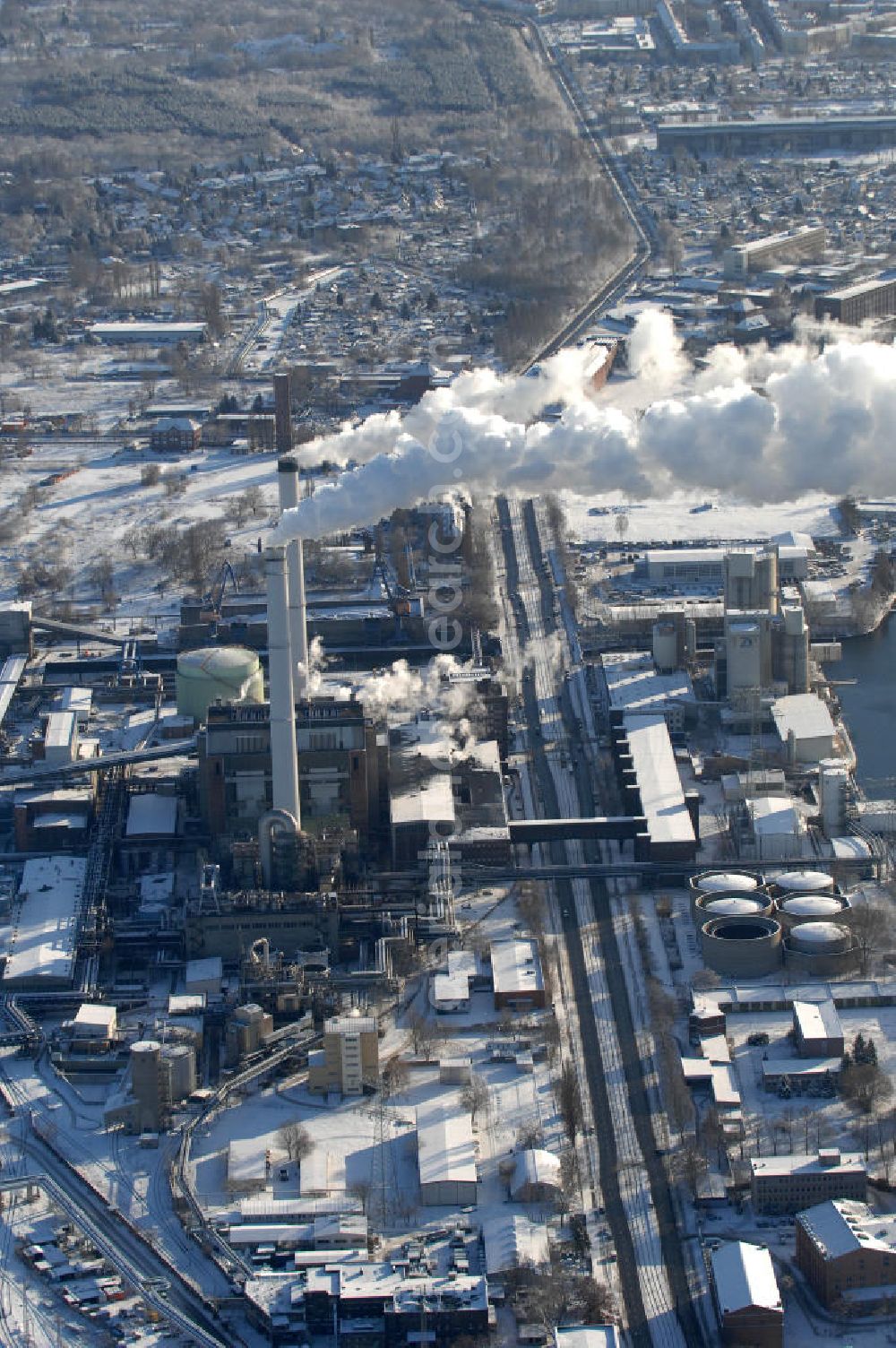 Aerial photograph Berlin - Blick auf das Heizkraftwerk Klingenberg an der Köpenicker Chaussee in Rummelsburg im winterlichen Schnee- Heizbetrieb. Berlin hat in den vergangenen Jahren seinen Beitrag zum Klimaschutz geleistet. Der Ausstoß des Klimagases Kohlendioxid ist seit 1990 um 14 Prozent zurückgegangen. Der Senat strebt an, bis 2010 diesen Wert auf 25 Prozent zu senken.Es stellt sich jedoch die Frage, ob die Anstrengungen der deutschen Hauptstadt angesichts der von den Vereinten Nationen formulierten Bedrohungsszenarien für das Weltklima ausreichen. Der Senat kündigte weitere Anstrengungen an. 2004 bliesen Berliner Kraftwerke, Fabriken, Autos und Haushalte noch immer 20 Millionen Tonnen Kohlendioxid in die Atmosphäre. Ein Großteil der Reduzierung rührt daher, dass viele Industrieanlagen inzwischen stillliegen. Auch die Kraftwerke sind sauberer geworden. Aber der Ausstoß aus den Sektoren Verkehr und Wolfgang Gerbere Haushalte hat sogar zugenommen.