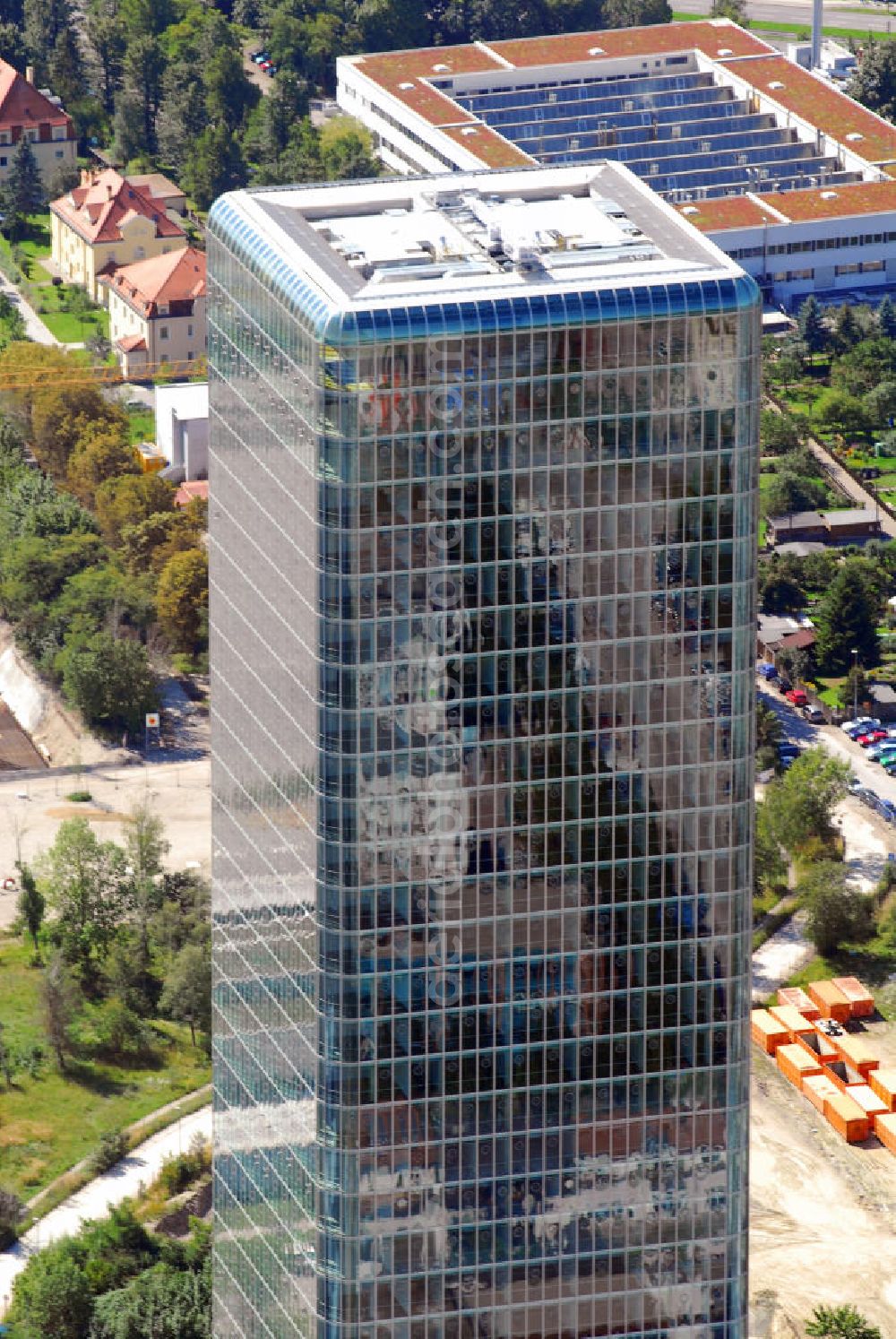 München from the bird's eye view: Blick auf das Hochhaus Uptown in München. Das Hochhaus Uptown am Georg-Brauchle-Ring in München ist mit einer Höhe von 146 m das (nach dem Olympiaturm) zweithöchste Bauwerk und mit seinen 37 Stockwerken auch das höchste Gebäude der Stadt. Geplant wurde der nach dreijähriger Bauzeit im Jahre 2004 im Komplex Uptown München im Stadtteil Moosach fertiggestellte Büroturm vom Architekturbüro Ingenhoven, Overdiek; Bauherr war die amerikanische Firma Hines, München. Die gläserne Fassade umhüllt das Tragwerk des Gebäudes wie eine gespannte Membran. Das Hochhaus mit 50.200 qm Fläche wird von vier siebengeschossigen „Campus“ genannten Gebäuden flankiert, die untereinan der mit einem transparenten Dach verbunden sind. In einem fünften Gebäude sind 139 Wohnungen untergebracht. Der Hauptnutzer des Hochhauses und der Campusgebäude ist die Deutschlandzentrale des Mobilfunkbetreibers O2. Im August 2006 kaufte die Government of Singapore Investment Corporation (GIC) das Hochhaus und eines der Campusgebäude für über 300 Millionen Euro. Kontakt: O2 Germany, Presseabteilung, Georg-Brauchle-Ring 23-25, 80992 München, Tel.: 089/2442-1201,