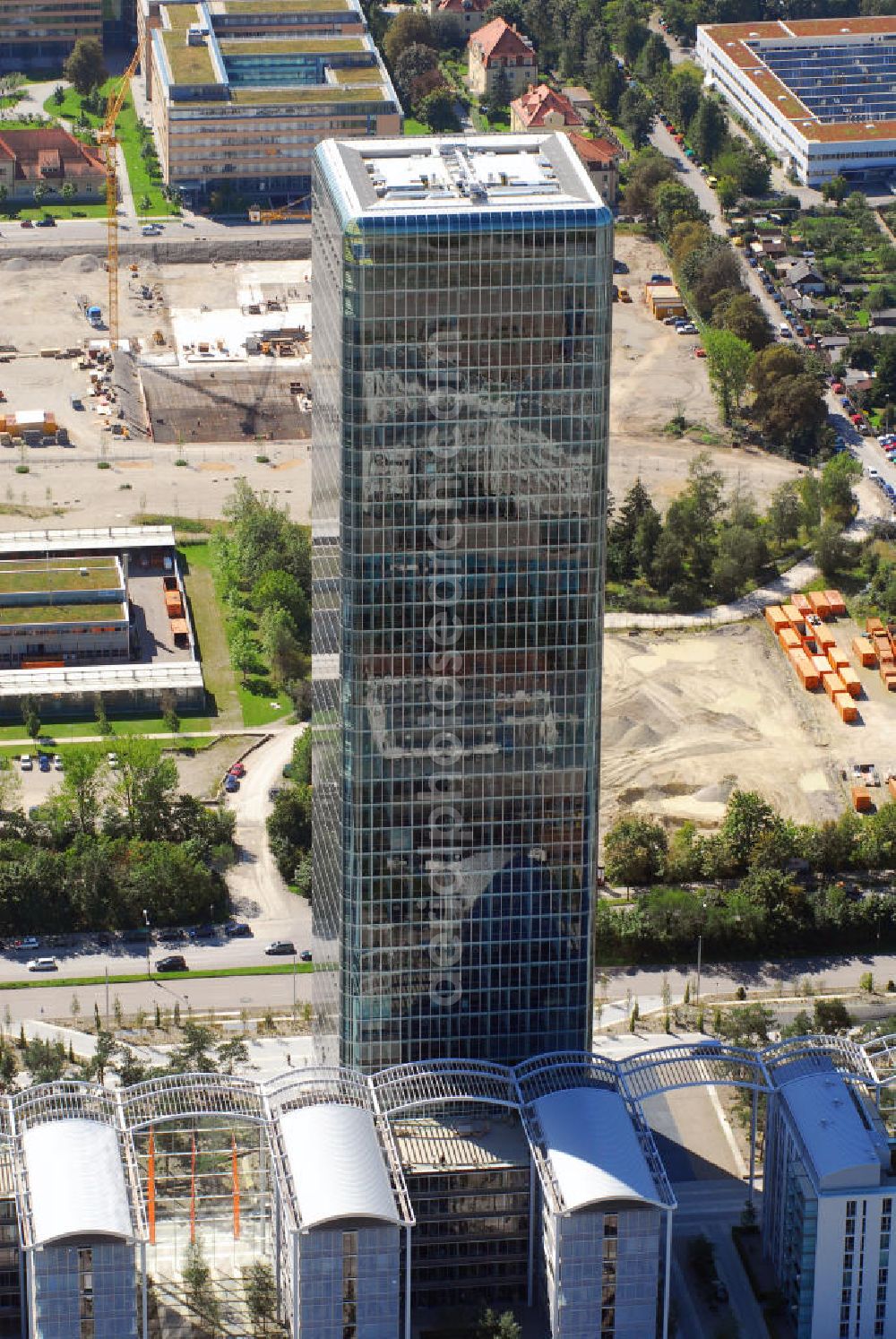 Aerial image München - Blick auf das Hochhaus Uptown in München. Das Hochhaus Uptown am Georg-Brauchle-Ring in München ist mit einer Höhe von 146 m das (nach dem Olympiaturm) zweithöchste Bauwerk und mit seinen 37 Stockwerken auch das höchste Gebäude der Stadt. Geplant wurde der nach dreijähriger Bauzeit im Jahre 2004 im Komplex Uptown München im Stadtteil Moosach fertiggestellte Büroturm vom Architekturbüro Ingenhoven, Overdiek; Bauherr war die amerikanische Firma Hines, München. Die gläserne Fassade umhüllt das Tragwerk des Gebäudes wie eine gespannte Membran. Das Hochhaus mit 50.200 qm Fläche wird von vier siebengeschossigen „Campus“ genannten Gebäuden flankiert, die untereinan der mit einem transparenten Dach verbunden sind. In einem fünften Gebäude sind 139 Wohnungen untergebracht. Der Hauptnutzer des Hochhauses und der Campusgebäude ist die Deutschlandzentrale des Mobilfunkbetreibers O2. Im August 2006 kaufte die Government of Singapore Investment Corporation (GIC) das Hochhaus und eines der Campusgebäude für über 300 Millionen Euro. Kontakt: O2 Germany, Presseabteilung, Georg-Brauchle-Ring 23-25, 80992 München, Tel.: 089/2442-1201,