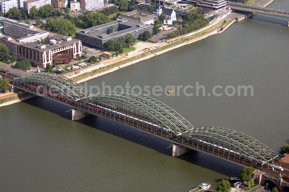 Köln from the bird's eye view: Blick auf die Hohenzollernbrücke in Köln. Sie führt über den Rhein und bestand ursprünglich aus zwei Eisenbahn- und einer Straßenbrücke. Die Hohenzollernbrücke löste 1911 die Dombrücke ab, die zuvor an der Stelle war, dem wachsenden Verkehr jedoch nicht mehr standhielt. Heute existiert die Straßenbrücke der Hohenzollernbrücke nicht mehr, sie wurde ebenfalls durch eine Eisenbahnbrücke ergänzt und die gesamte Brücke links und rechts durch Fußgänger- und Radwege erweitert.