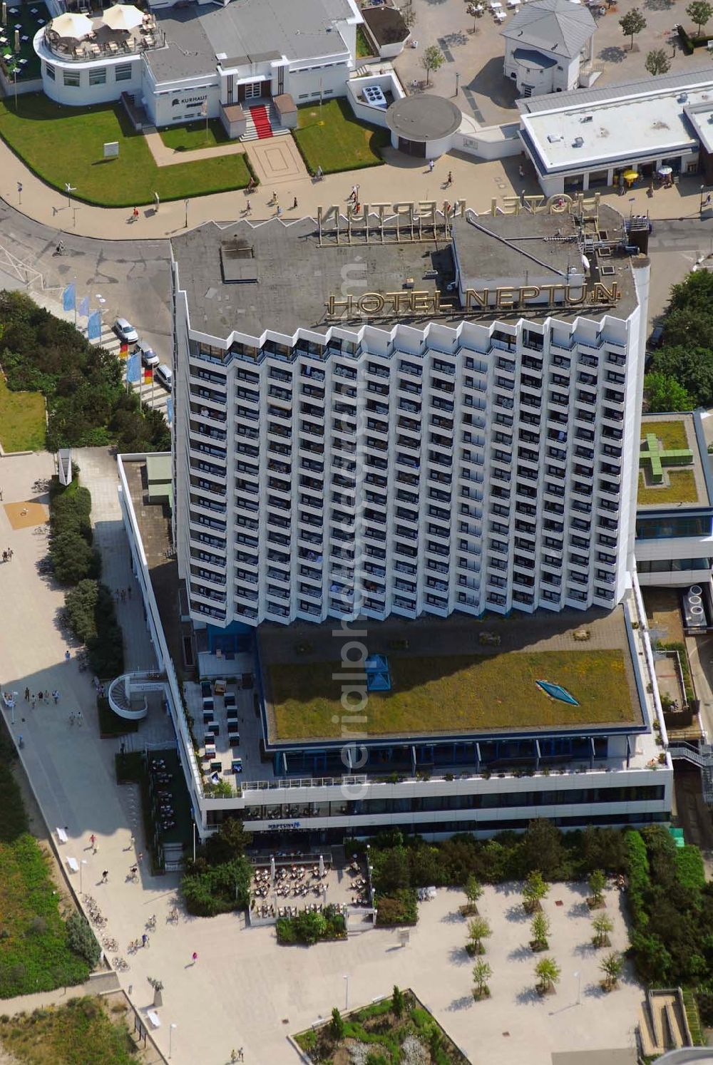 Warnemünde from the bird's eye view: Blick auf das Hotel Neptun, ein direkt am Strand der Ostsee gelegenes 5-Sterne-Hotel im Ostseebad Warnemünde, das 1971 den Betrieb aufnahm. Das Hotel mit 338 Zimmern und dem ersten zertifizierten Thalassozentrum Deutschlandes gehört als „Wellness-Hotel“ zur Arkona AG, einer 100%igen Tochter der Deutschen Seereederei Rostock (DSR). Das ehem.Wohnungsbaukombinat Rostock und das schwedische Unternehmen SIAB errichteten von 1969 bis 1971 den 64 Meter hohen Betonklotz, der im Frühjahr 1971 eröffnet wurde. Die Architekten hatten den Bau so geplant, dass alle der rund 350 Zimmer mit Meeresblick waren. Neben den einheimischen Urlaubern übernachteten auch Geschäftsleute aus dem Westen gern in dem Prestige-Objekt. Hinzu kamen Staatsgäste wie Fidel Castro, aber auch westdeutsche Politiker wie Uwe Barschel und Willy Brandt. Für die Staatssicherheit der DDR eine gute Gelegenheit Informationen zu sammeln.