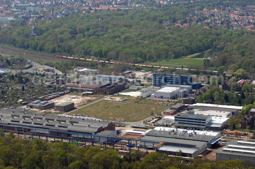 Aerial image Dessau - Blick auf das Industriegelände des ehemaligen VEB Waggonbau Dessau. Der VEB Waggonbau Dessau war einer der größten Hersteller von Schienenfahrzeug-Waggons in der ehemaligen DDR und einer der größten Hersteller von Kühlwaggons in der Welt. Am 24. Juli 1990 erfolgte die Eintragung als Waggonbau Dessau GmbH in das Handelsregister. Zum 1. Juli 1995 erfolgte die Schließung der Waggonbau Dessau GmbH. Als Nachfolgeeinrichtungen entstanden auf dem Gelände die Fahrzeugtechnik Dessau, die als Nachfolgeunternehmen ca. 200 Mitarbeiter übernahm, ein Industriepark sowie eine Qualifizierungsgesellschaft. Kontakt: FTD Fahrzeugtechnik Dessau AG i.I., 06844 Dessau-Roßlau, Am Waggonbau 11, Tel. +49 (0)340 25 370, Fax +49 (0)340 25 37105, EMail zentrale@fahrzeugtechnik-dessau.de