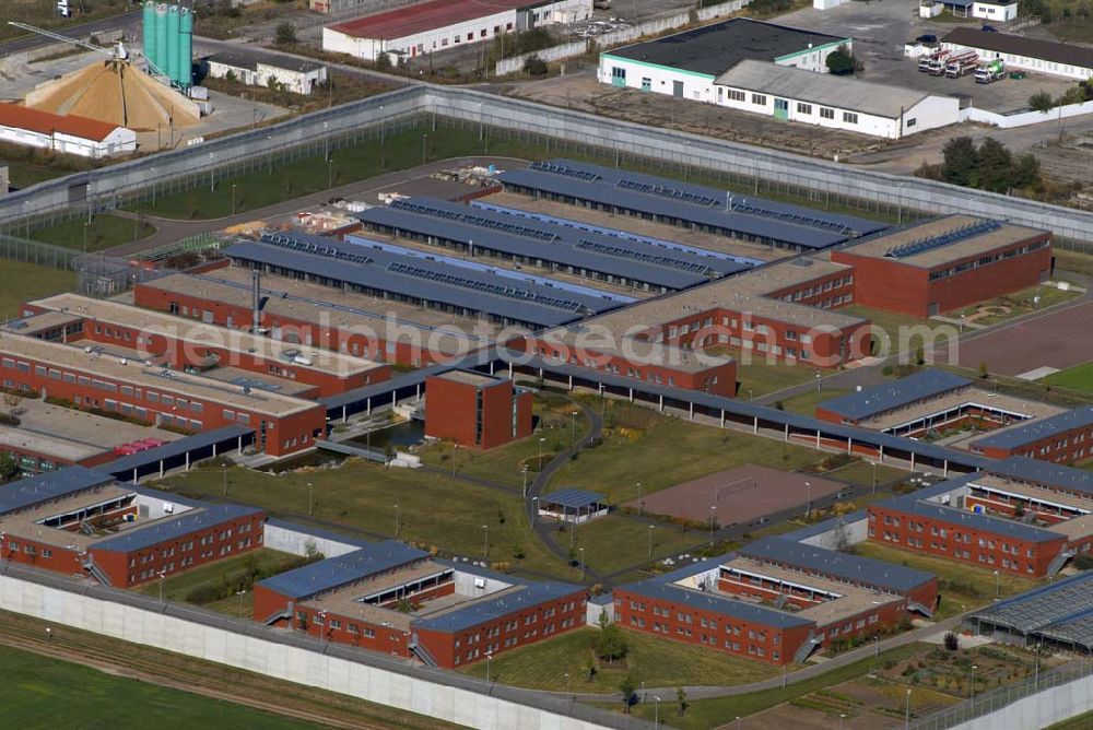 Aerial image Raßnitz - Blick auf die Jugendanstalt Raßnitz, sie ist im südöstlichen Teil Sachsen-Anhalts - nahezu genau in der geographischen Mitte - zwischen Halle und Leipzig gelegen und erstreckt sich über eine Fläche von ca. 16 ha. Sie wurde in einer Bauzeit von 28 Monaten errichtet. Die Unterkunftshäuser sind für einen modernen, zeitgemäßen Wohngruppenvollzug konzipiert. Das heißt, die jungen Gefangenen sind grundsätzlich in Einzelhafträumen untergebracht, die jeweils zu Wohngruppen mit 12 bis maximal 20 Inhaftierten zusammengefasst sind. Die jungen Gefangenen haben dadurch die Möglichkeit, im Gruppenleben soziale Verhaltensweisen zur gewaltlosen Konfliktlösung zu üben, gegenseitige Rücksichtsnahme zu entwickeln und soziale Anpassung im Kleinen als Übung für die Anpassung an die Gesellschaft zu trainieren. Die Ausbildung mit dem Ziel eines Schul- bzw. Berufsabschlusses ist eine wesentliche Grundvoraussetzung, um ein erneutes Straffälligwerden der jungen Gefangenen zu verhindern und ihnen eine Lebensperspektive zu eröffnen. In der Anstaltsinternen Schule können die jungen Gefangenen die Schulabschlüsse der Sekundarstufe I (9. / 10. Klasse) erreichen.