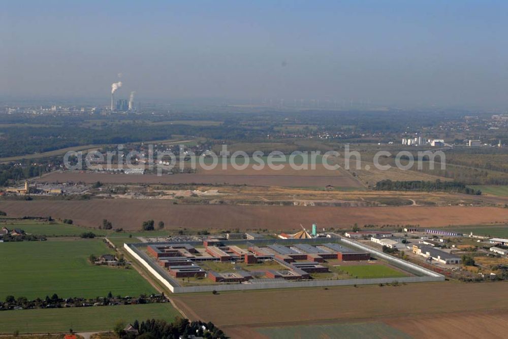 Aerial image Raßnitz - Blick auf die Jugendanstalt Raßnitz, sie ist im südöstlichen Teil Sachsen-Anhalts - nahezu genau in der geographischen Mitte - zwischen Halle und Leipzig gelegen und erstreckt sich über eine Fläche von ca. 16 ha. Sie wurde in einer Bauzeit von 28 Monaten errichtet. Die Unterkunftshäuser sind für einen modernen, zeitgemäßen Wohngruppenvollzug konzipiert. Das heißt, die jungen Gefangenen sind grundsätzlich in Einzelhafträumen untergebracht, die jeweils zu Wohngruppen mit 12 bis maximal 20 Inhaftierten zusammengefasst sind. Die jungen Gefangenen haben dadurch die Möglichkeit, im Gruppenleben soziale Verhaltensweisen zur gewaltlosen Konfliktlösung zu üben, gegenseitige Rücksichtsnahme zu entwickeln und soziale Anpassung im Kleinen als Übung für die Anpassung an die Gesellschaft zu trainieren. Die Ausbildung mit dem Ziel eines Schul- bzw. Berufsabschlusses ist eine wesentliche Grundvoraussetzung, um ein erneutes Straffälligwerden der jungen Gefangenen zu verhindern und ihnen eine Lebensperspektive zu eröffnen. In der Anstaltsinternen Schule können die jungen Gefangenen die Schulabschlüsse der Sekundarstufe I (9. / 10. Klasse) erreichen.