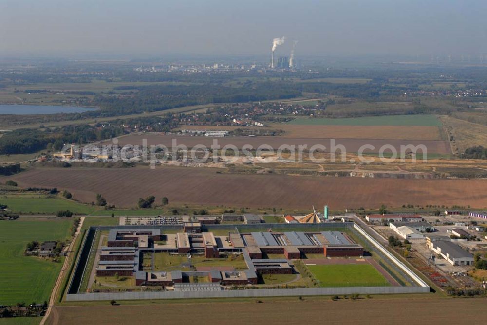 Raßnitz from the bird's eye view: Blick auf die Jugendanstalt Raßnitz, sie ist im südöstlichen Teil Sachsen-Anhalts - nahezu genau in der geographischen Mitte - zwischen Halle und Leipzig gelegen und erstreckt sich über eine Fläche von ca. 16 ha. Sie wurde in einer Bauzeit von 28 Monaten errichtet. Die Unterkunftshäuser sind für einen modernen, zeitgemäßen Wohngruppenvollzug konzipiert. Das heißt, die jungen Gefangenen sind grundsätzlich in Einzelhafträumen untergebracht, die jeweils zu Wohngruppen mit 12 bis maximal 20 Inhaftierten zusammengefasst sind. Die jungen Gefangenen haben dadurch die Möglichkeit, im Gruppenleben soziale Verhaltensweisen zur gewaltlosen Konfliktlösung zu üben, gegenseitige Rücksichtsnahme zu entwickeln und soziale Anpassung im Kleinen als Übung für die Anpassung an die Gesellschaft zu trainieren. Die Ausbildung mit dem Ziel eines Schul- bzw. Berufsabschlusses ist eine wesentliche Grundvoraussetzung, um ein erneutes Straffälligwerden der jungen Gefangenen zu verhindern und ihnen eine Lebensperspektive zu eröffnen. In der Anstaltsinternen Schule können die jungen Gefangenen die Schulabschlüsse der Sekundarstufe I (9. / 10. Klasse) erreichen.