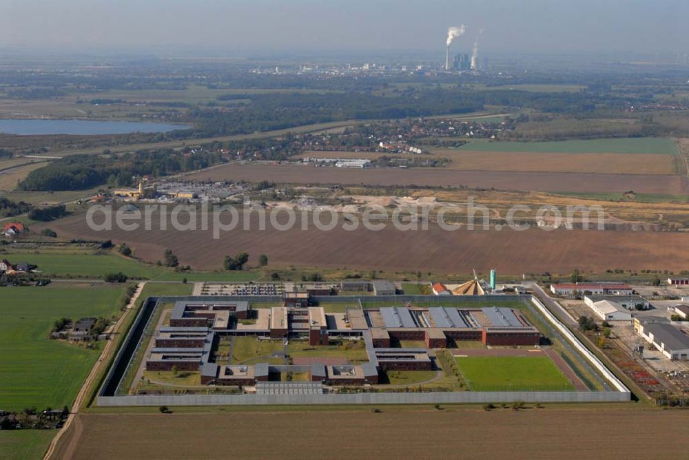 Aerial image Raßnitz - Blick auf die Jugendanstalt Raßnitz, sie ist im südöstlichen Teil Sachsen-Anhalts - nahezu genau in der geographischen Mitte - zwischen Halle und Leipzig gelegen und erstreckt sich über eine Fläche von ca. 16 ha. Sie wurde in einer Bauzeit von 28 Monaten errichtet. Die Unterkunftshäuser sind für einen modernen, zeitgemäßen Wohngruppenvollzug konzipiert. Das heißt, die jungen Gefangenen sind grundsätzlich in Einzelhafträumen untergebracht, die jeweils zu Wohngruppen mit 12 bis maximal 20 Inhaftierten zusammengefasst sind. Die jungen Gefangenen haben dadurch die Möglichkeit, im Gruppenleben soziale Verhaltensweisen zur gewaltlosen Konfliktlösung zu üben, gegenseitige Rücksichtsnahme zu entwickeln und soziale Anpassung im Kleinen als Übung für die Anpassung an die Gesellschaft zu trainieren. Die Ausbildung mit dem Ziel eines Schul- bzw. Berufsabschlusses ist eine wesentliche Grundvoraussetzung, um ein erneutes Straffälligwerden der jungen Gefangenen zu verhindern und ihnen eine Lebensperspektive zu eröffnen. In der Anstaltsinternen Schule können die jungen Gefangenen die Schulabschlüsse der Sekundarstufe I (9. / 10. Klasse) erreichen.