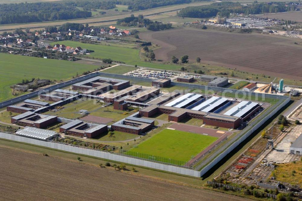 Raßnitz from the bird's eye view: Blick auf die Jugendanstalt Raßnitz, sie ist im südöstlichen Teil Sachsen-Anhalts - nahezu genau in der geographischen Mitte - zwischen Halle und Leipzig gelegen und erstreckt sich über eine Fläche von ca. 16 ha. Sie wurde in einer Bauzeit von 28 Monaten errichtet. Die Unterkunftshäuser sind für einen modernen, zeitgemäßen Wohngruppenvollzug konzipiert. Das heißt, die jungen Gefangenen sind grundsätzlich in Einzelhafträumen untergebracht, die jeweils zu Wohngruppen mit 12 bis maximal 20 Inhaftierten zusammengefasst sind. Die jungen Gefangenen haben dadurch die Möglichkeit, im Gruppenleben soziale Verhaltensweisen zur gewaltlosen Konfliktlösung zu üben, gegenseitige Rücksichtsnahme zu entwickeln und soziale Anpassung im Kleinen als Übung für die Anpassung an die Gesellschaft zu trainieren. Die Ausbildung mit dem Ziel eines Schul- bzw. Berufsabschlusses ist eine wesentliche Grundvoraussetzung, um ein erneutes Straffälligwerden der jungen Gefangenen zu verhindern und ihnen eine Lebensperspektive zu eröffnen. In der Anstaltsinternen Schule können die jungen Gefangenen die Schulabschlüsse der Sekundarstufe I (9. / 10. Klasse) erreichen.