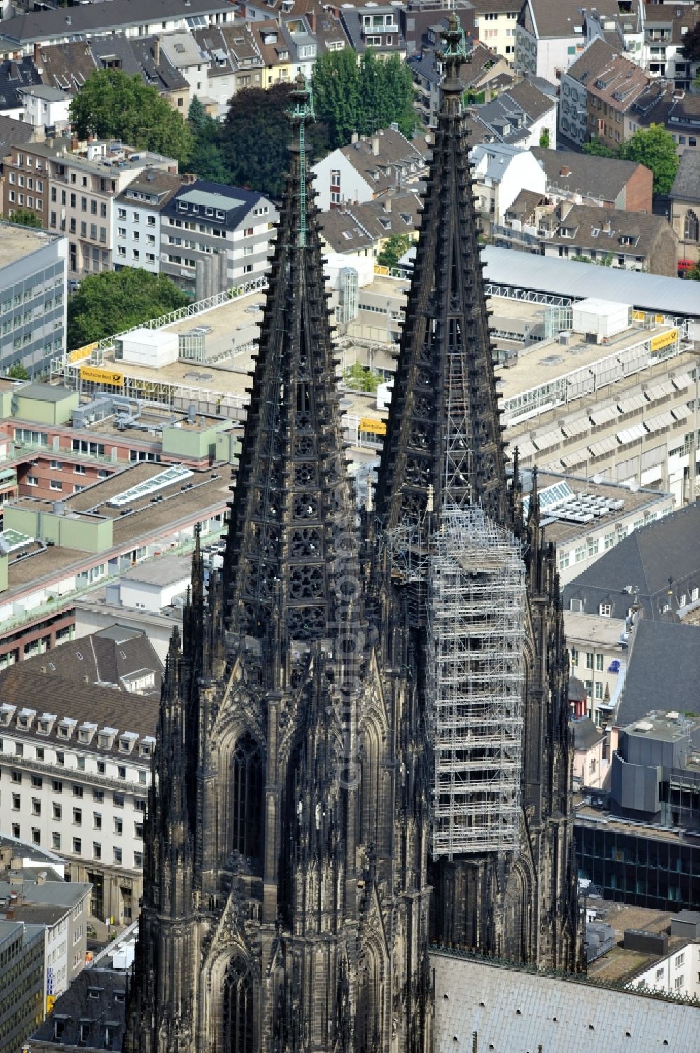 Köln from above - View of the Cologne Cathedral with scaffolding on the north tower.The the 157-meter high Gothic building, whose construction started in 1248 and was completed in 1880, belongs to the UNESCO World Heritage since 1996 and is redeveloped again and again. Currently, two frameworks are at the north tower of the cathedral, thus the stonemasons can expand the connecting elements of the sandstone, restore angel figurines and fix old war damage