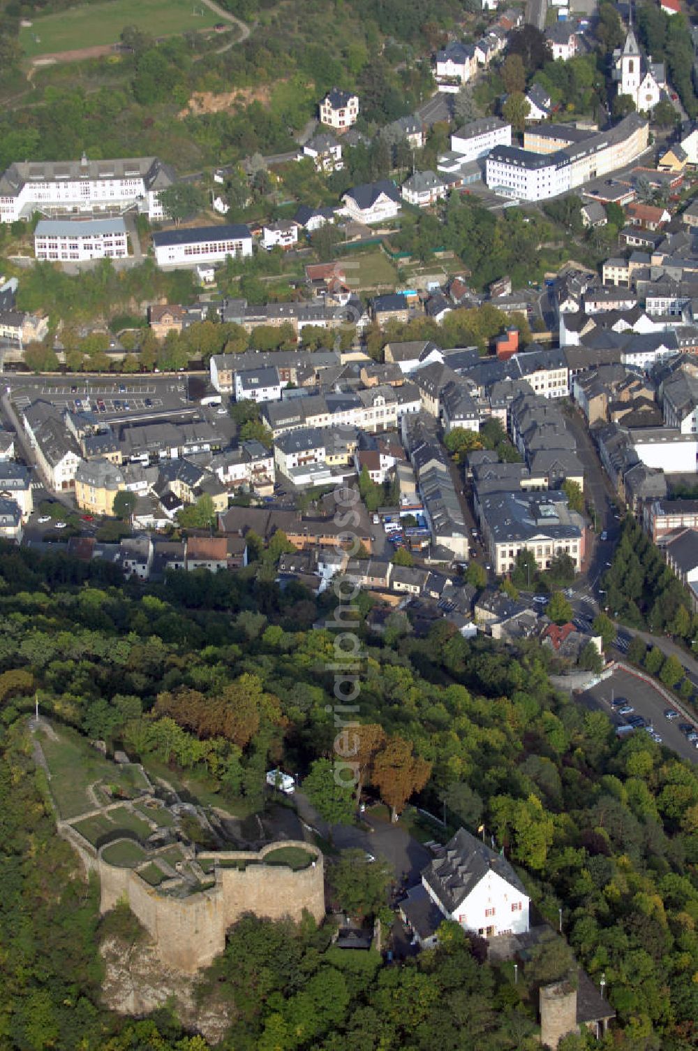 Aerial photograph Kirn - Blick auf die Kyrburg nahe der Stadt Kirn, deren Wahrzeichen sie ist. Die Burg wurde 1128 erstmals urkundlich erwähnt und war eine der Stammburgen der Wildgrafen. Anfang des 15. Jahrhunderts ging die Kyrburg durch eine Hochzeit in den Besitz der Rheingrafen über. Im Dreißigjährigen Krieg besetzten die Spanier, Schweden und kaiserlichen Truppen die Burg und gelangte 1681 schließlich in französische Hände. Daraufhin erneuerte man die Befestigungsanlagen, die 1734 auch durch die Franzosen wieder gesprengt wurden. Die Burg war nur noch eine Ruine und diente den Kirnern fortan als Steinbruch. Mitte des 18. Jahrhunderts wurde das Garnisionshaus gebaut, in dem sich heute das Burgrestaurant und das Whiskey-Museum befinden. Seit 1988 ist die Burg nun Eigentum der Stadt Kirn und dient als Freilichtbühne oder Kulisse für kulturelle Ereignisse wie Opern, Theaterstücke oder Konzerte. Im Hintergrund der Burg ist die Stadt Kirn zu sehen. Sie hat knapp 9000 Einwohner und liegt im Landkreis Bad Kreuznach im Hunsrück. Kontakt: Stadtverwaltung Kirn, Kirchstraße 3 55606 Kirn, Tel. +49(0)6752 135 0, Fax +49(0)6752 135 250, Email: info@kirn.de