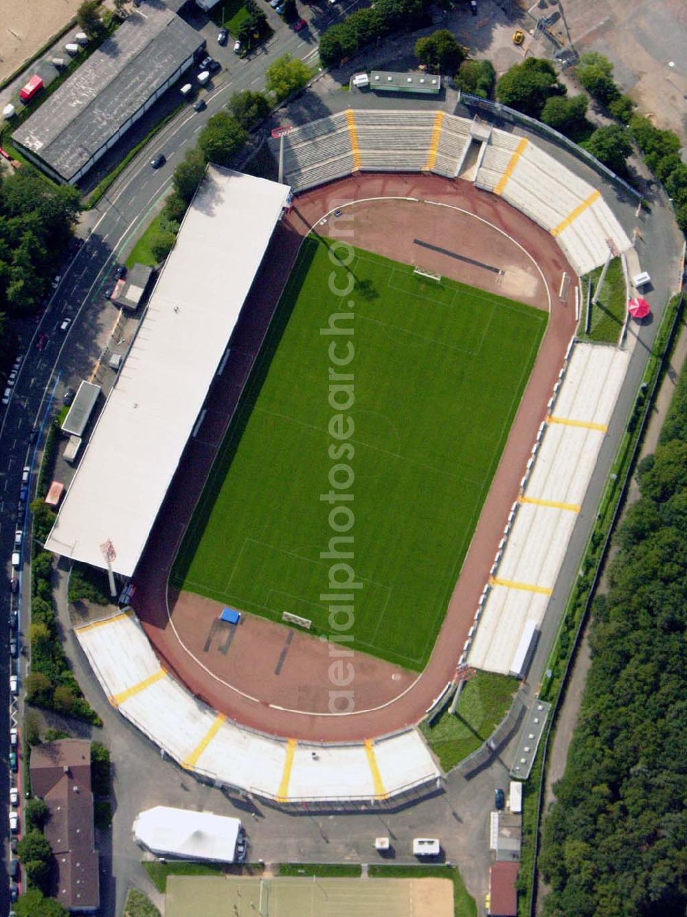 Siegen from the bird's eye view: 27.08.2005 Siegen; Seit dem letzten Umbau hat das Leimbachstadion ein Fassungsvermögen von ca. 18.500 Plätzen Zuschauern. Knapp 2.000 Sitzplätze befinden sich unter dem Dach der Haupttribüne, dazu auch noch weitere rund 1.200 Stehplätze. Seit zwei Jahren existiert ein modernisierter Gästeblock und auch die restlichen Stehstufen wurden mittlerweile komplett erneuert.