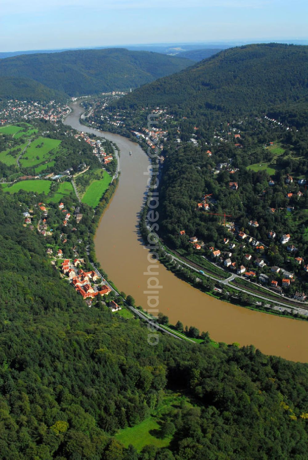 Heidelberg / OT Ziegelhausen from the bird's eye view: Blick auf den Verlauf des Neckar nahe Ziegelhausen, einem Stadtteil von Heidelberg. Der östlich von Heidelberg gelegene, 1975 eingemeindete Stadtteil, hat über 9.000 Einwohner (1997). Die herrliche Lage Ziegelhausens entlang des Neckars bis hinauf zu den Höhen des Odenwalds, insbesondere auch die Fülle der Ausflugsmöglichkeiten, ein dichtes Angebot an Hotels und Gastwirtschaften, Kloster Neuburg, das Textilmuseum sowie die Nähe zu Heidelbergs Altstadt und zum Schloß machen es zu einem beliebten Ausflugs- und Erholungsziel. Der Neckar ist ein 367 km langer Nebenfluss des Rheins, der überwiegend in Baden-Württemberg verläuft und in seinem Unterlauf auf einem kurzen Streckenabschnitt die Landesgrenze mit Hessen bildet. Er entspringt im Naturschutzgebiet Schwenninger Moos bei Villingen-Schwenningen auf 706 m Meereshöhe und mündet bei Mannheim in den Rhein (95 m).