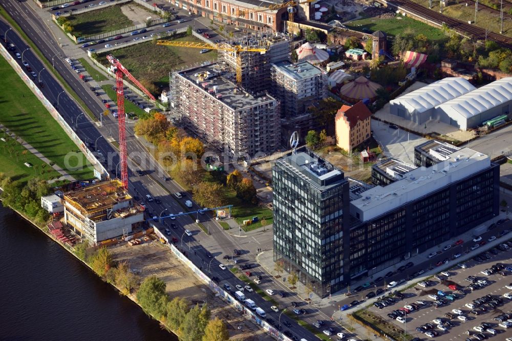 Aerial photograph Berlin - View of the construction of the new headquarters of Mercedes Benz Germany and a construction project by Schrobsdorff Bau AG at Mühlenstrasse in Berlin Friedrichshain. On the banks of the river Spree an apartment house is being built with a view of the East Side Gallery on the the Berlin Wall remains. The planning of the project was overseen by the office Dahm Architects & Engineers. In the immediate vicinity the Mercedes-Benz Sales Germany brings together its previous locations in a new property, which was designed and built by CA Immo