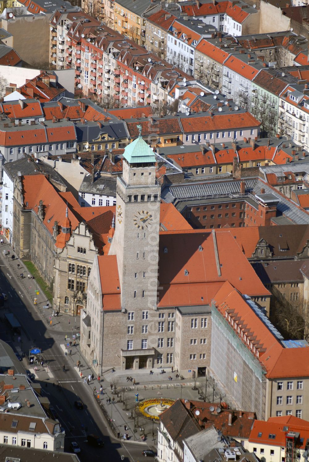 Aerial photograph Berlin - Blick auf das Rathaus Neukölln an der Karl-Marx-Strasse.Das Rathaus, 1905-09 errichtet, fällt durch den hohen, stadtbildprägenden Turmbau auf. Rieke uff'n Rathausturm wird die auf dem 68 Meter hohen Turm als Windfahne angebrachte Glückgöttin Fortuna genannt. Eine weitere Besonderheit besteht in der optischen und funktionalen Gliederung des Gebäudekomplexes in zwei Teile; Verwaltung und Büros sind in den schlichten Flügeln entlang der Erkstraße untergebracht, während sich das eigentliche Rathaus in repräsentativer Lage an der Karl-Marx-Straße befindet. Seiner Nutzung entsprechend lagen hier die Sitzungssäle sowie der Saal des Bürgermeisters. Diese Konzeption des Stadtbaurates Kiehl, die Repräsentations- und Verwaltungsgebäude in unterschiedlichen Gebäudeteilen unterzubringen, war für die damalige Zeit eine Neuheit. Der Verwaltungsteil wurde von Kiehl in den Jahren 1910-12 erweitert. 1950 und 1952-53 erfolgten weitere Anbauten durch Hans Eichler bzw. Hans Freese.