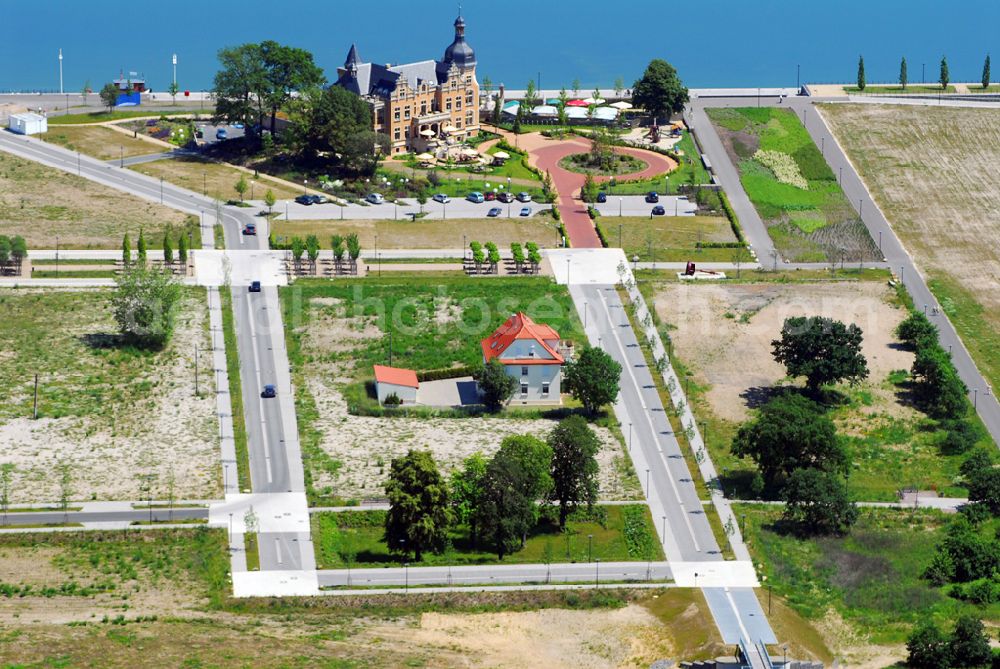 Bitterfeld from above - Blick auf die Rekultivierungsfläche am Bersteinsee in Bitterfeld.Das Gelände an der B100 in Richtung Goitzschewird geschückt durch ein Anwesen, das den phantasievollen Namen „Villa am Bernsteinsee“ trägt. Die ehemals „Biermannsche Villa“ wurde 1896 im prunkvollen Stil der Neorenaissance für den Jeßnitzer Fabrikanten Biermann errichtet. Bis zum 2. Weltkrieg wurde sie als repräsentatives Wohnhaus dieser Familie genutzt. Nach dem Krieg ging das Gebäude in Volkseigentum über und diente fortan für bis zu 10 Familien als Wohnhaus. Nach 1990, als auch die neben der Villa gelegene Papierfabrik stillgelegt wurde, kehrte Leere in das große Gebäude ein. Mit den Jahren taten Verfall, Vandalismus und zwei Brände das ihre, um eine trostlose Ruine zu schaffen. Villa Bernstein GmbH, Mühlenboulevard 4,D - 06749 Bitterfeld, Geschäftsführer: Herr Halbritter, Leitung vor Ort: Herr Scholz, Herr Eisenmann Telefon: 0 34 93/ 92 93 98, info@villa-am-bernsteinsee.com