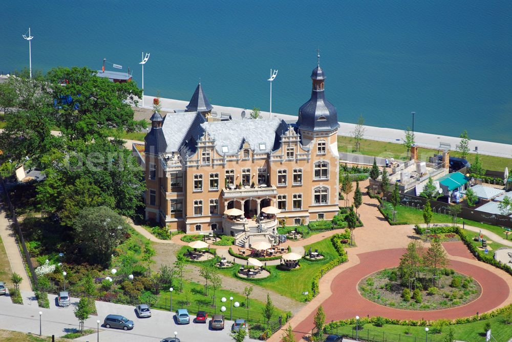 Aerial image Bitterfeld - Blick auf die Rekultivierungsfläche am Bersteinsee in Bitterfeld.Das Gelände an der B100 in Richtung Goitzschewird geschückt durch ein Anwesen, das den phantasievollen Namen „Villa am Bernsteinsee“ trägt. Die ehemals „Biermannsche Villa“ wurde 1896 im prunkvollen Stil der Neorenaissance für den Jeßnitzer Fabrikanten Biermann errichtet. Bis zum 2. Weltkrieg wurde sie als repräsentatives Wohnhaus dieser Familie genutzt. Nach dem Krieg ging das Gebäude in Volkseigentum über und diente fortan für bis zu 10 Familien als Wohnhaus. Nach 1990, als auch die neben der Villa gelegene Papierfabrik stillgelegt wurde, kehrte Leere in das große Gebäude ein. Mit den Jahren taten Verfall, Vandalismus und zwei Brände das ihre, um eine trostlose Ruine zu schaffen. Villa Bernstein GmbH, Mühlenboulevard 4,D - 06749 Bitterfeld, Geschäftsführer: Herr Halbritter, Leitung vor Ort: Herr Scholz, Herr Eisenmann Telefon: 0 34 93/ 92 93 98, info@villa-am-bernsteinsee.com