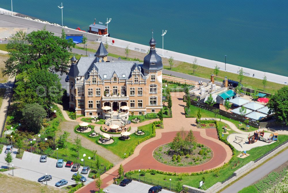 Aerial photograph Bitterfeld - Blick auf die Rekultivierungsfläche am Bersteinsee in Bitterfeld.Das Gelände an der B100 in Richtung Goitzschewird geschückt durch ein Anwesen, das den phantasievollen Namen „Villa am Bernsteinsee“ trägt. Die ehemals „Biermannsche Villa“ wurde 1896 im prunkvollen Stil der Neorenaissance für den Jeßnitzer Fabrikanten Biermann errichtet. Bis zum 2. Weltkrieg wurde sie als repräsentatives Wohnhaus dieser Familie genutzt. Nach dem Krieg ging das Gebäude in Volkseigentum über und diente fortan für bis zu 10 Familien als Wohnhaus. Nach 1990, als auch die neben der Villa gelegene Papierfabrik stillgelegt wurde, kehrte Leere in das große Gebäude ein. Mit den Jahren taten Verfall, Vandalismus und zwei Brände das ihre, um eine trostlose Ruine zu schaffen. Villa Bernstein GmbH, Mühlenboulevard 4,D - 06749 Bitterfeld, Geschäftsführer: Herr Halbritter, Leitung vor Ort: Herr Scholz, Herr Eisenmann Telefon: 0 34 93/ 92 93 98, info@villa-am-bernsteinsee.com