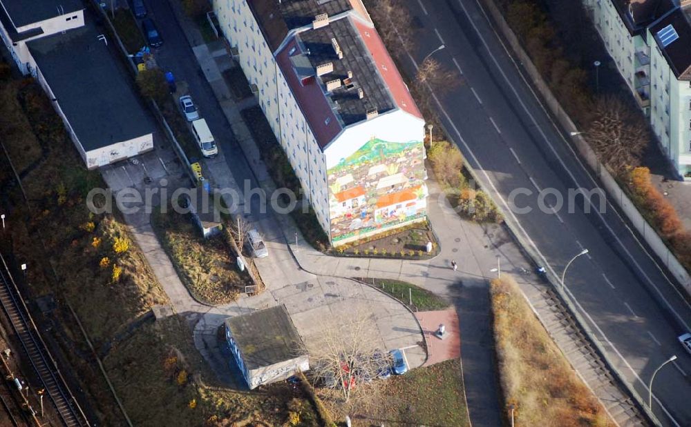 Berlin from above - Blick auf das restaurierte Giebelwand-Gemälde an der Lichtenberger Brücke. Das Gemälde mit dem Titel Nicaraguanisches Dorf – Monimbó 1978, unter Mitwirkung von Martin Hoffmann und Trakia Wendisch erstellt, wurde am 27. August 1985 dem Stadtbezirk Lichtenberg übergeben. Es stellt auf einer bemalten Fläche von 255 m² in vielen kleinen Geschichten das tägliche Leben und den Kampf der unterdrückten Bevölkerung dar, man zählt das Gemälde zu den größten Wandgemälden mit naiver Malerei in der Welt, es fand inzwischen weltweit Beachtung. Im Auftrag des Magistrats von Berlin und des Kulturministeriums der DDR, wurde im Sommer 1985 von Manuel García Moia, Nationalpreis-träger für Naive Kunst Nicaraguas, gemeinsam mit den Berliner Künst-lern Trakia Wendisch und Martin Hoffmann das Gemälde direkt auf einer schwarz grundierten Putzschicht gemalt. Schicht für Schicht wurden die hellen Farben aufgetragen bis sie leuchteten. Mit einer Fläche von 255 qm zählt das Berliner Mural zu den größten und schönsten Bildern naiver Malerei der Welt. Es ist Zeugnis einer außerordentlichen kreativen Kunstepoche der Muralkunst in Lateinamerika.