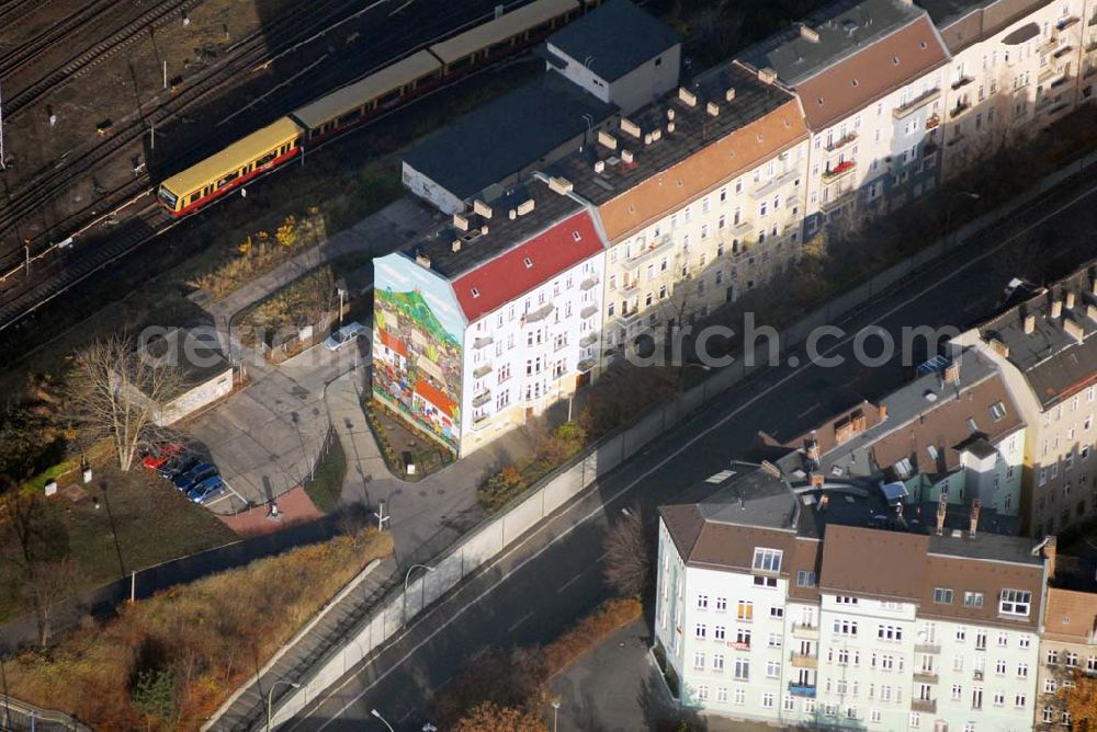 Berlin from the bird's eye view: Blick auf das restaurierte Giebelwand-Gemälde an der Lichtenberger Brücke. Das Gemälde mit dem Titel Nicaraguanisches Dorf – Monimbó 1978, unter Mitwirkung von Martin Hoffmann und Trakia Wendisch erstellt, wurde am 27. August 1985 dem Stadtbezirk Lichtenberg übergeben. Es stellt auf einer bemalten Fläche von 255 m² in vielen kleinen Geschichten das tägliche Leben und den Kampf der unterdrückten Bevölkerung dar, man zählt das Gemälde zu den größten Wandgemälden mit naiver Malerei in der Welt, es fand inzwischen weltweit Beachtung. Im Auftrag des Magistrats von Berlin und des Kulturministeriums der DDR, wurde im Sommer 1985 von Manuel García Moia, Nationalpreis-träger für Naive Kunst Nicaraguas, gemeinsam mit den Berliner Künst-lern Trakia Wendisch und Martin Hoffmann das Gemälde direkt auf einer schwarz grundierten Putzschicht gemalt. Schicht für Schicht wurden die hellen Farben aufgetragen bis sie leuchteten. Mit einer Fläche von 255 qm zählt das Berliner Mural zu den größten und schönsten Bildern naiver Malerei der Welt. Es ist Zeugnis einer außerordentlichen kreativen Kunstepoche der Muralkunst in Lateinamerika.