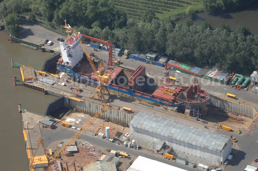 Aerial image Wewelsfleth - Blick auf eine Schiffswerft in Wewelsfleth. Die Peters Schiffbau GmbH ist ein Traditionsunternehmen und der größte Arbeitgeber der Gemeinde. Seit 1871 ist die Werft von Jürgen Peters die alleinige Werft in Wewelsfleth. Das mittelständische Unternehmen ist direkt an der Störmündung zu Elbe ansässig und baut dort Schiffe mit einer Länge bis zu 137,80m für internationale Kunden. Kontakt: Am Hafen 6, 25599 Wewelsfleth, Fax +49 4829 71 290, Tel. +49 4829 71 0, Homepage