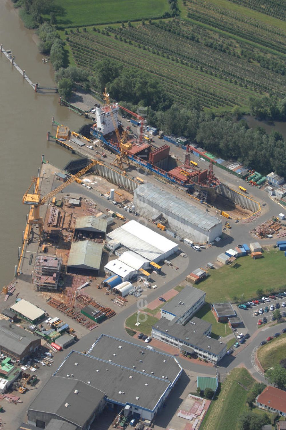 Wewelsfleth from above - Blick auf eine Schiffswerft in Wewelsfleth. Die Peters Schiffbau GmbH ist ein Traditionsunternehmen und der größte Arbeitgeber der Gemeinde. Seit 1871 ist die Werft von Jürgen Peters die alleinige Werft in Wewelsfleth. Das mittelständische Unternehmen ist direkt an der Störmündung zu Elbe ansässig und baut dort Schiffe mit einer Länge bis zu 137,80m für internationale Kunden. Kontakt: Am Hafen 6, 25599 Wewelsfleth, Fax +49 4829 71 290, Tel. +49 4829 71 0, Homepage