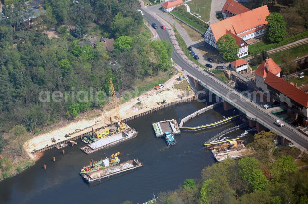 Aerial photograph Kleinmachnow - Die Schleuse Kleinmachnow liegt im Teltowkanal und besteht aus 3 Schleusenkammern und einem Wehrdurchlass (Freiarche). Die zwei 67 m langen Schleusenkammern (im Bild links) wurden 1905 in Mauerwerksbauweise errichtet. 1940 wurde eine 3. Schleusenkammer in Spundwandbauweise erbaut, die Schiffe bis 85 m Länge schleusen kann. Die gesamte Anlage einschließlich Brücke und Schleusenstand steht unter Denkmalschutz. Im Rahmen des Verkehrsprojektes Deutsche Einheit Nr. 17 soll hier eine neue Schleuse gebaut werden, die von bis zu 185 m langen Schiffsverbänden passiert werden kann. Die Planung sieht eine 190 m lange Kammer in der vorhandenen Nordkammer vor.