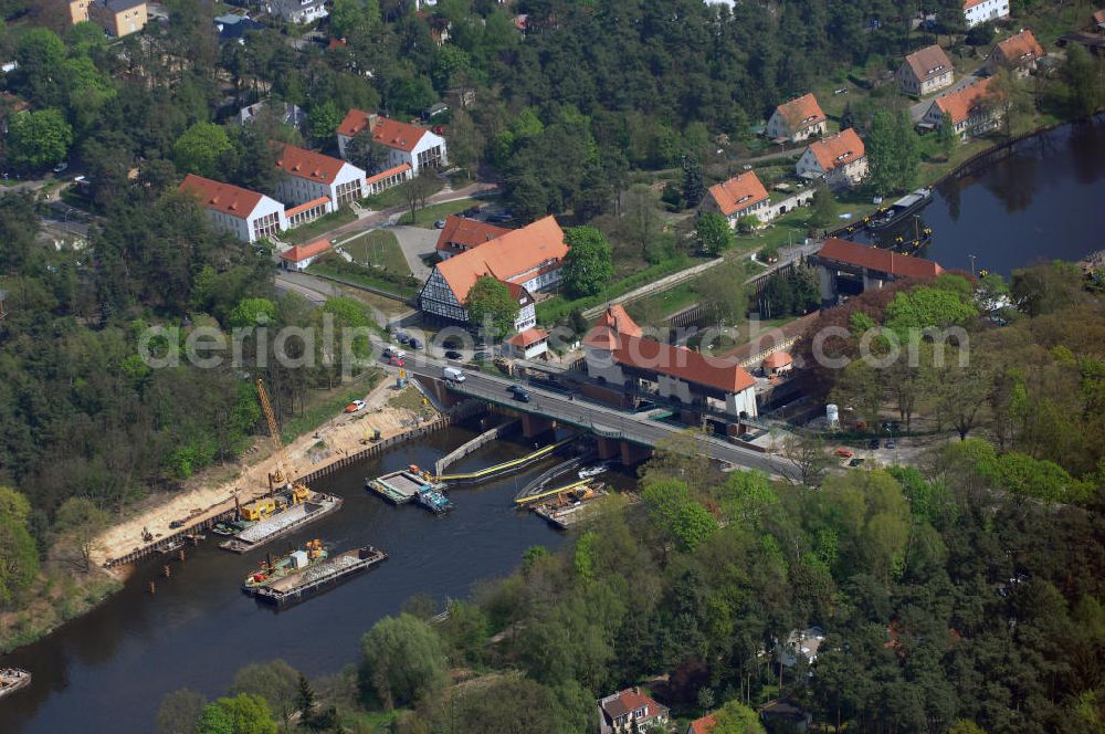 Kleinmachnow from above - Die Schleuse Kleinmachnow liegt im Teltowkanal und besteht aus 3 Schleusenkammern und einem Wehrdurchlass (Freiarche). Die zwei 67 m langen Schleusenkammern (im Bild links) wurden 1905 in Mauerwerksbauweise errichtet. 1940 wurde eine 3. Schleusenkammer in Spundwandbauweise erbaut, die Schiffe bis 85 m Länge schleusen kann. Die gesamte Anlage einschließlich Brücke und Schleusenstand steht unter Denkmalschutz. Im Rahmen des Verkehrsprojektes Deutsche Einheit Nr. 17 soll hier eine neue Schleuse gebaut werden, die von bis zu 185 m langen Schiffsverbänden passiert werden kann. Die Planung sieht eine 190 m lange Kammer in der vorhandenen Nordkammer vor.