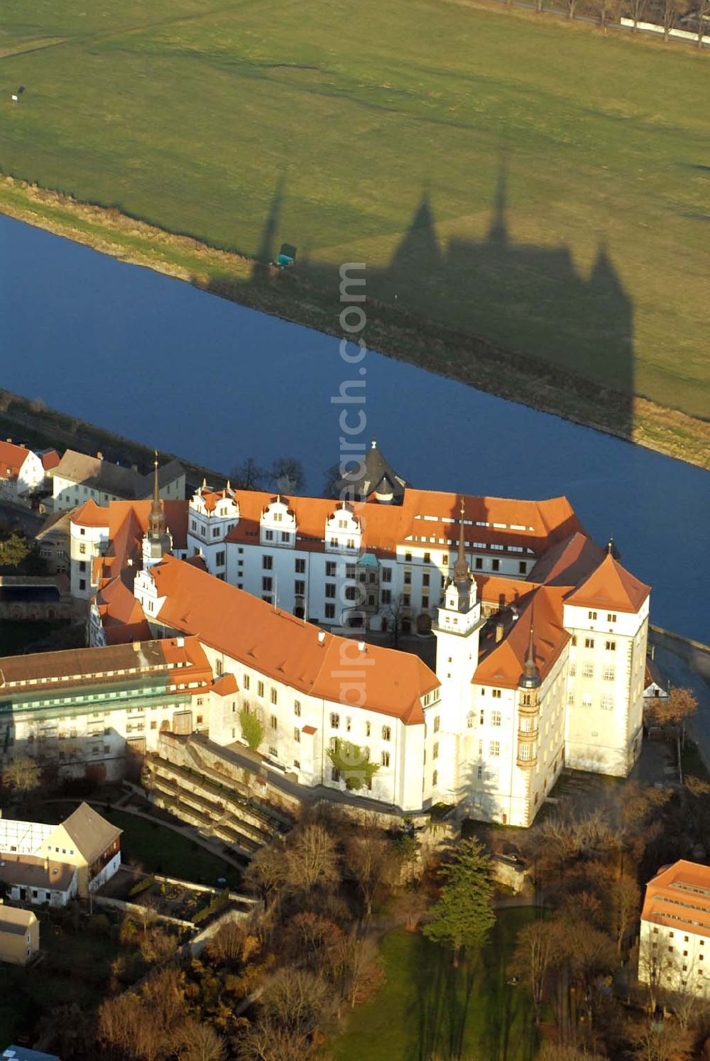 Aerial image Torgau - Blick auf Schloss Hartenfels an der Elbe. Es ist ein prachtvolles Renaissanceschloss in der Stadt Torgau im Freistaat Sachsen.Der Schlossbau wurde im 15. Jahrhundert von Konrad Pflüger, einem Schüler Arnolds von Westfalen begonnen und im 16. Jahrhundert von Konrad Krebs fortgeführt. Es war einer der Hofhaltungssitze der sächsischen Kurfürsten aus dem Hause Wettin und ist das größte vollständig erhaltene Schloss der Frührenaissance Deutschlands. Im Schlossinneren befindet sich der Wendelstein, eine fast 20 Meter hohe freitragende steinerne Wendeltreppe. Die Kapelle von Schloss Hartenfels war der erste protestantische Kirchenbau der Welt. Sie wurde 1544 von Martin Luther eingeweiht. Nachdem die albertinischen Wettiner im 16. Jahrhundert ihren Hofhaltungssitz dauerhaft nach Dresden verlegten, wurde das Schloss hauptsächlich als Verwaltungsgebäude genutzt. 1815 gelangte es an das Königreich Preußen und diente nunmehr der preußischen Verwaltung des neugebildeten Kreises Torgau.