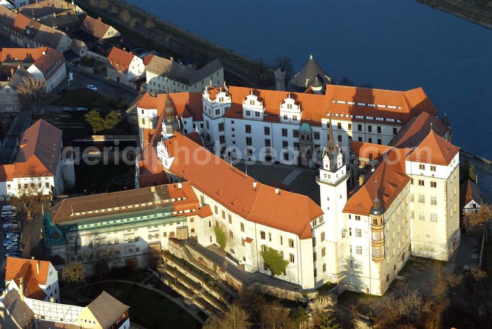 Aerial photograph Torgau - Blick auf Schloss Hartenfels an der Elbe. Es ist ein prachtvolles Renaissanceschloss in der Stadt Torgau im Freistaat Sachsen.Der Schlossbau wurde im 15. Jahrhundert von Konrad Pflüger, einem Schüler Arnolds von Westfalen begonnen und im 16. Jahrhundert von Konrad Krebs fortgeführt. Es war einer der Hofhaltungssitze der sächsischen Kurfürsten aus dem Hause Wettin und ist das größte vollständig erhaltene Schloss der Frührenaissance Deutschlands. Im Schlossinneren befindet sich der Wendelstein, eine fast 20 Meter hohe freitragende steinerne Wendeltreppe. Die Kapelle von Schloss Hartenfels war der erste protestantische Kirchenbau der Welt. Sie wurde 1544 von Martin Luther eingeweiht. Nachdem die albertinischen Wettiner im 16. Jahrhundert ihren Hofhaltungssitz dauerhaft nach Dresden verlegten, wurde das Schloss hauptsächlich als Verwaltungsgebäude genutzt. 1815 gelangte es an das Königreich Preußen und diente nunmehr der preußischen Verwaltung des neugebildeten Kreises Torgau.