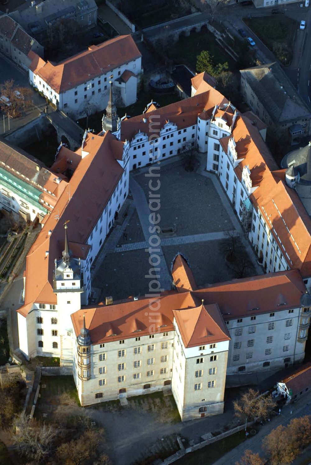 Aerial image Torgau - Blick auf Schloss Hartenfels an der Elbe. Es ist ein prachtvolles Renaissanceschloss in der Stadt Torgau im Freistaat Sachsen.Der Schlossbau wurde im 15. Jahrhundert von Konrad Pflüger, einem Schüler Arnolds von Westfalen begonnen und im 16. Jahrhundert von Konrad Krebs fortgeführt. Es war einer der Hofhaltungssitze der sächsischen Kurfürsten aus dem Hause Wettin und ist das größte vollständig erhaltene Schloss der Frührenaissance Deutschlands. Im Schlossinneren befindet sich der Wendelstein, eine fast 20 Meter hohe freitragende steinerne Wendeltreppe. Die Kapelle von Schloss Hartenfels war der erste protestantische Kirchenbau der Welt. Sie wurde 1544 von Martin Luther eingeweiht. Nachdem die albertinischen Wettiner im 16. Jahrhundert ihren Hofhaltungssitz dauerhaft nach Dresden verlegten, wurde das Schloss hauptsächlich als Verwaltungsgebäude genutzt. 1815 gelangte es an das Königreich Preußen und diente nunmehr der preußischen Verwaltung des neugebildeten Kreises Torgau.