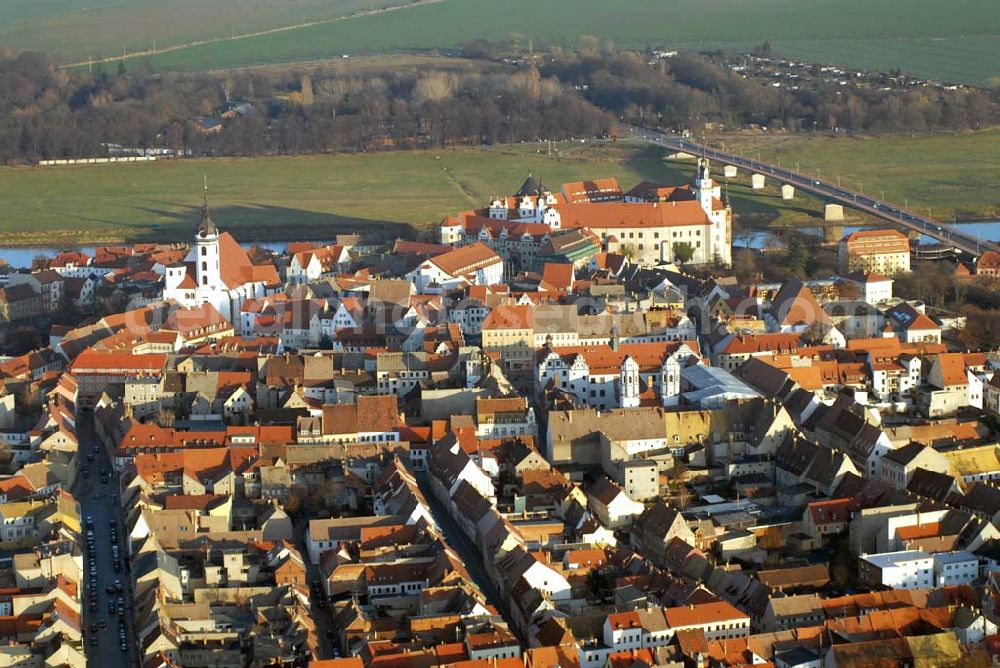 Torgau from the bird's eye view: Blick auf Schloss Hartenfels an der Elbe. Es ist ein prachtvolles Renaissanceschloss in der Stadt Torgau im Freistaat Sachsen.Der Schlossbau wurde im 15. Jahrhundert von Konrad Pflüger, einem Schüler Arnolds von Westfalen begonnen und im 16. Jahrhundert von Konrad Krebs fortgeführt. Es war einer der Hofhaltungssitze der sächsischen Kurfürsten aus dem Hause Wettin und ist das größte vollständig erhaltene Schloss der Frührenaissance Deutschlands. Im Schlossinneren befindet sich der Wendelstein, eine fast 20 Meter hohe freitragende steinerne Wendeltreppe. Die Kapelle von Schloss Hartenfels war der erste protestantische Kirchenbau der Welt. Sie wurde 1544 von Martin Luther eingeweiht. Nachdem die albertinischen Wettiner im 16. Jahrhundert ihren Hofhaltungssitz dauerhaft nach Dresden verlegten, wurde das Schloss hauptsächlich als Verwaltungsgebäude genutzt. 1815 gelangte es an das Königreich Preußen und diente nunmehr der preußischen Verwaltung des neugebildeten Kreises Torgau.