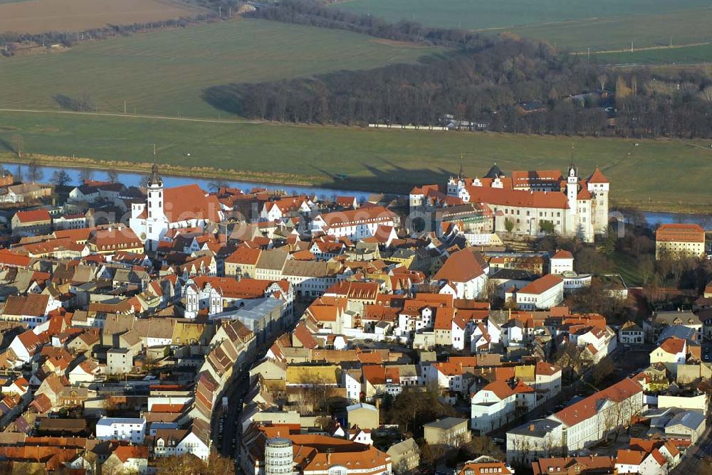 Aerial image Torgau - Blick auf Schloss Hartenfels an der Elbe. Es ist ein prachtvolles Renaissanceschloss in der Stadt Torgau im Freistaat Sachsen.Der Schlossbau wurde im 15. Jahrhundert von Konrad Pflüger, einem Schüler Arnolds von Westfalen begonnen und im 16. Jahrhundert von Konrad Krebs fortgeführt. Es war einer der Hofhaltungssitze der sächsischen Kurfürsten aus dem Hause Wettin und ist das größte vollständig erhaltene Schloss der Frührenaissance Deutschlands. Im Schlossinneren befindet sich der Wendelstein, eine fast 20 Meter hohe freitragende steinerne Wendeltreppe. Die Kapelle von Schloss Hartenfels war der erste protestantische Kirchenbau der Welt. Sie wurde 1544 von Martin Luther eingeweiht. Nachdem die albertinischen Wettiner im 16. Jahrhundert ihren Hofhaltungssitz dauerhaft nach Dresden verlegten, wurde das Schloss hauptsächlich als Verwaltungsgebäude genutzt. 1815 gelangte es an das Königreich Preußen und diente nunmehr der preußischen Verwaltung des neugebildeten Kreises Torgau.