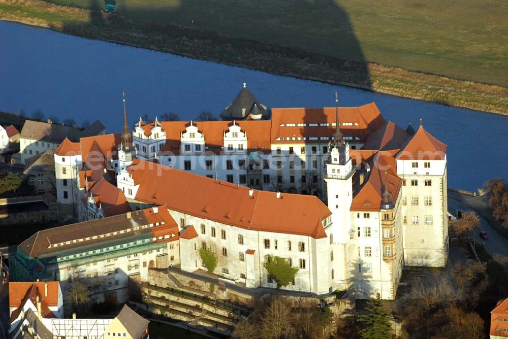 Aerial photograph Torgau - Blick auf Schloss Hartenfels an der Elbe. Es ist ein prachtvolles Renaissanceschloss in der Stadt Torgau im Freistaat Sachsen.Der Schlossbau wurde im 15. Jahrhundert von Konrad Pflüger, einem Schüler Arnolds von Westfalen begonnen und im 16. Jahrhundert von Konrad Krebs fortgeführt. Es war einer der Hofhaltungssitze der sächsischen Kurfürsten aus dem Hause Wettin und ist das größte vollständig erhaltene Schloss der Frührenaissance Deutschlands. Im Schlossinneren befindet sich der Wendelstein, eine fast 20 Meter hohe freitragende steinerne Wendeltreppe. Die Kapelle von Schloss Hartenfels war der erste protestantische Kirchenbau der Welt. Sie wurde 1544 von Martin Luther eingeweiht. Nachdem die albertinischen Wettiner im 16. Jahrhundert ihren Hofhaltungssitz dauerhaft nach Dresden verlegten, wurde das Schloss hauptsächlich als Verwaltungsgebäude genutzt. 1815 gelangte es an das Königreich Preußen und diente nunmehr der preußischen Verwaltung des neugebildeten Kreises Torgau.