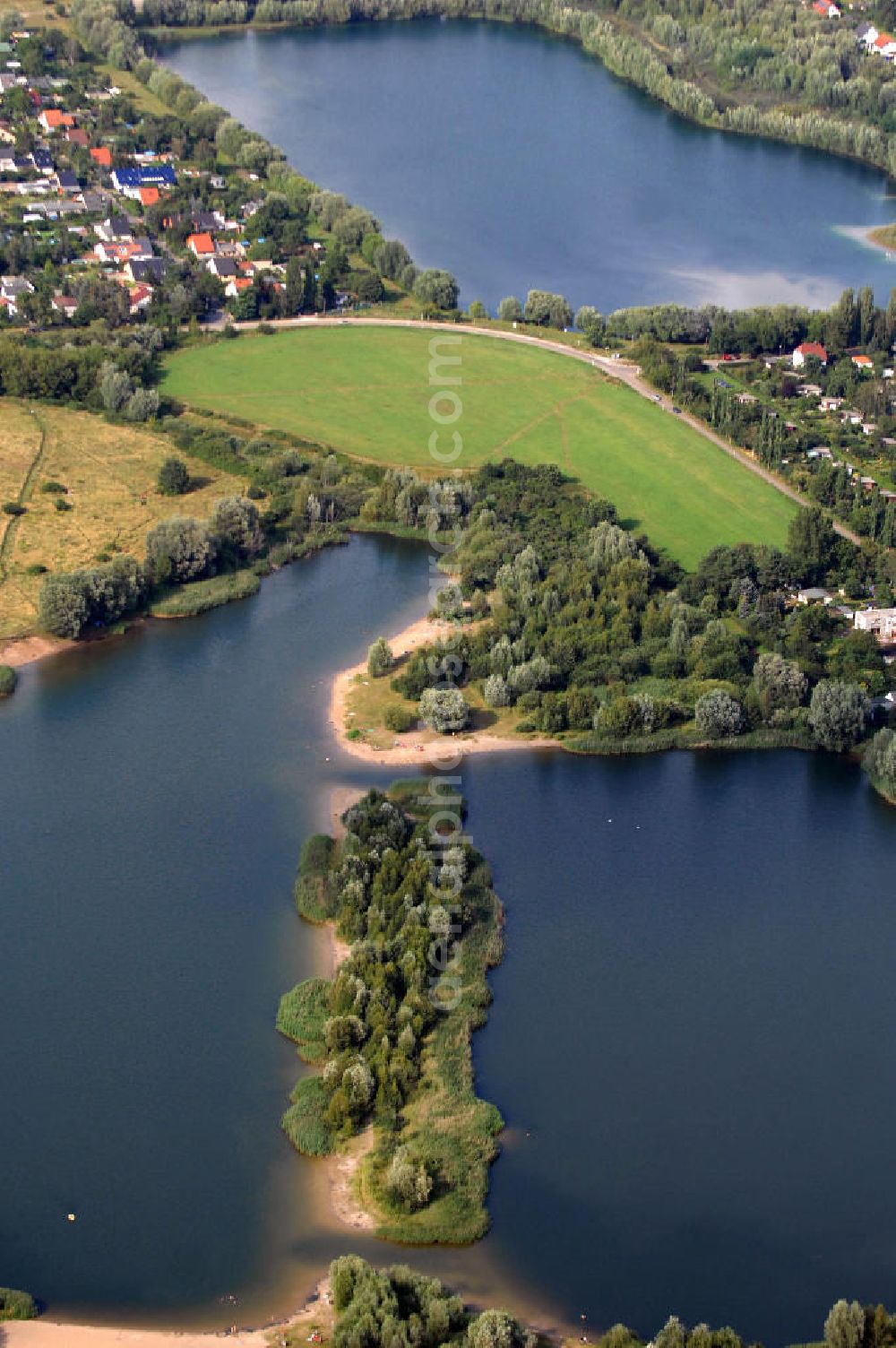 Aerial image Berlin - Blick auf 2 Seen im Bezirk Marzahn-Hellersdorf. Im Vordergrund befindet sich mit dem Habermannsee und dem dahintergelegenen Kaulsdorfer Busch ein Teil der sogenannten Kaulsdorfer Seen, ein Landschaftsschutzgebiet im Ortsteil Kaulsdorf-Süd am Kressenweg, an dem sich mehrere Wongebiete entlangziehen. Der See in der Bildmitte ist der zu Mahlsdorf-Süd gehörende Elsensee an der Elsenstraße. Dahinter ist der Berliner Balkon zu sehen, ein unbebauter Hang an der Grenze zwischen Kaulsdorf und Mahlsdorf. Im oberen Teil des Bildes ist ein Gewerbegebiet an der B1 / Neuenhagener Straße zu erkennen, zu dem zum Beispiel eine Filiale des OBI-Baumarktes gehört.