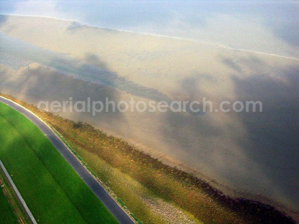 Greetsiel from the bird's eye view: 18.10.2005 Greetsiel; Seit 1991 bildet das Sperrwerk Leysiel mit Siel und Schleuse das Abschlussbauwerk der Deichnase Leyhörn, dem Kernstück der Küstenschutzmaßnahme Leybucht. Das 30 Meter breite Siel unterstützt die Entwässerungsfunktion der Anlagen in Greetsiel und Leybuchtsiel. Der Binnendeichs gelegene 200 Hektar große Speichersee dient sowohl der Aufnahme des durch die Siele abfließenden Wassers als auch als Stauraum, wenn im Falle mehrtägiger Sturmfluten das Binnenwasser über Schöpfwerke hineingepumpt wird.