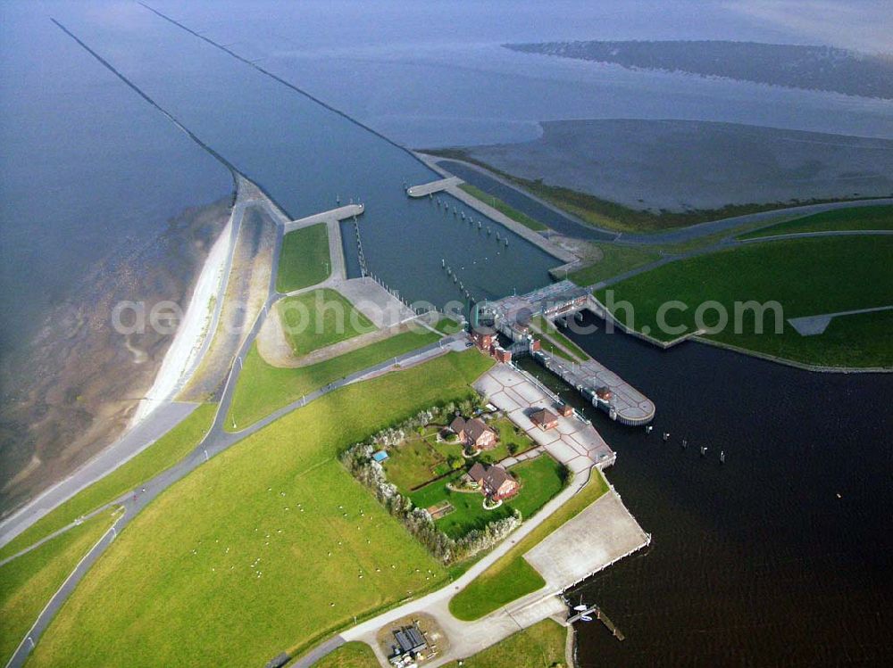 Aerial image Greetsiel - 18.10.2005 Greetsiel; Seit 1991 bildet das Sperrwerk Leysiel mit Siel und Schleuse das Abschlussbauwerk der Deichnase Leyhörn, dem Kernstück der Küstenschutzmaßnahme Leybucht. Das 30 Meter breite Siel unterstützt die Entwässerungsfunktion der Anlagen in Greetsiel und Leybuchtsiel. Der Binnendeichs gelegene 200 Hektar große Speichersee dient sowohl der Aufnahme des durch die Siele abfließenden Wassers als auch als Stauraum, wenn im Falle mehrtägiger Sturmfluten das Binnenwasser über Schöpfwerke hineingepumpt wird.