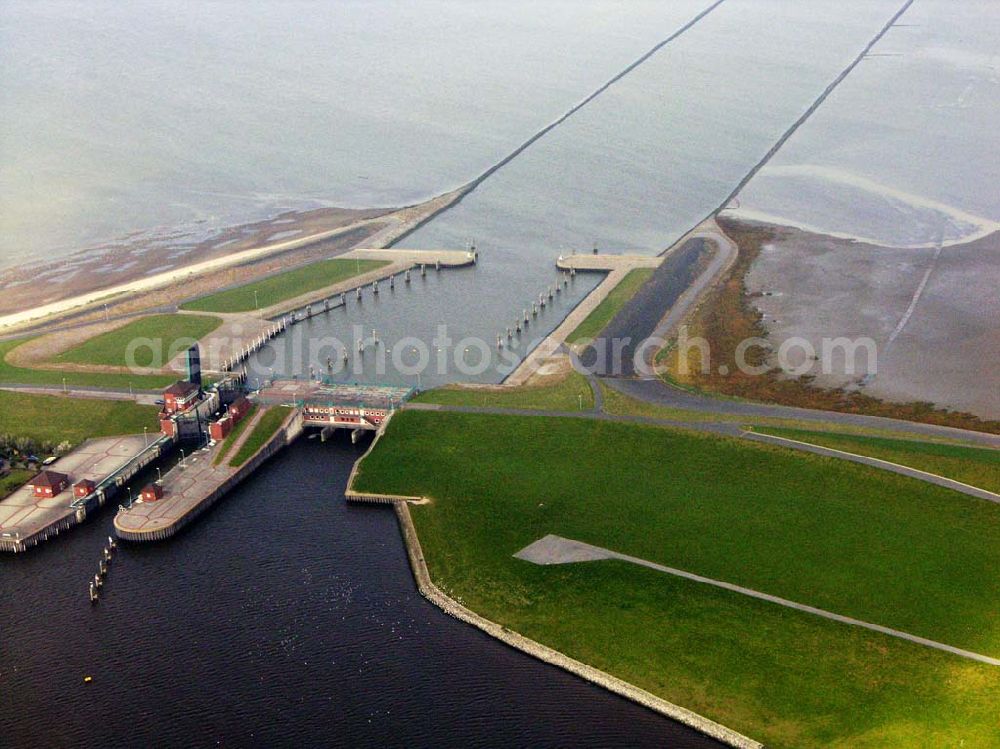 Aerial photograph Greetsiel - 18.10.2005 Greetsiel; Seit 1991 bildet das Sperrwerk Leysiel mit Siel und Schleuse das Abschlussbauwerk der Deichnase Leyhörn, dem Kernstück der Küstenschutzmaßnahme Leybucht. Das 30 Meter breite Siel unterstützt die Entwässerungsfunktion der Anlagen in Greetsiel und Leybuchtsiel. Der Binnendeichs gelegene 200 Hektar große Speichersee dient sowohl der Aufnahme des durch die Siele abfließenden Wassers als auch als Stauraum, wenn im Falle mehrtägiger Sturmfluten das Binnenwasser über Schöpfwerke hineingepumpt wird.