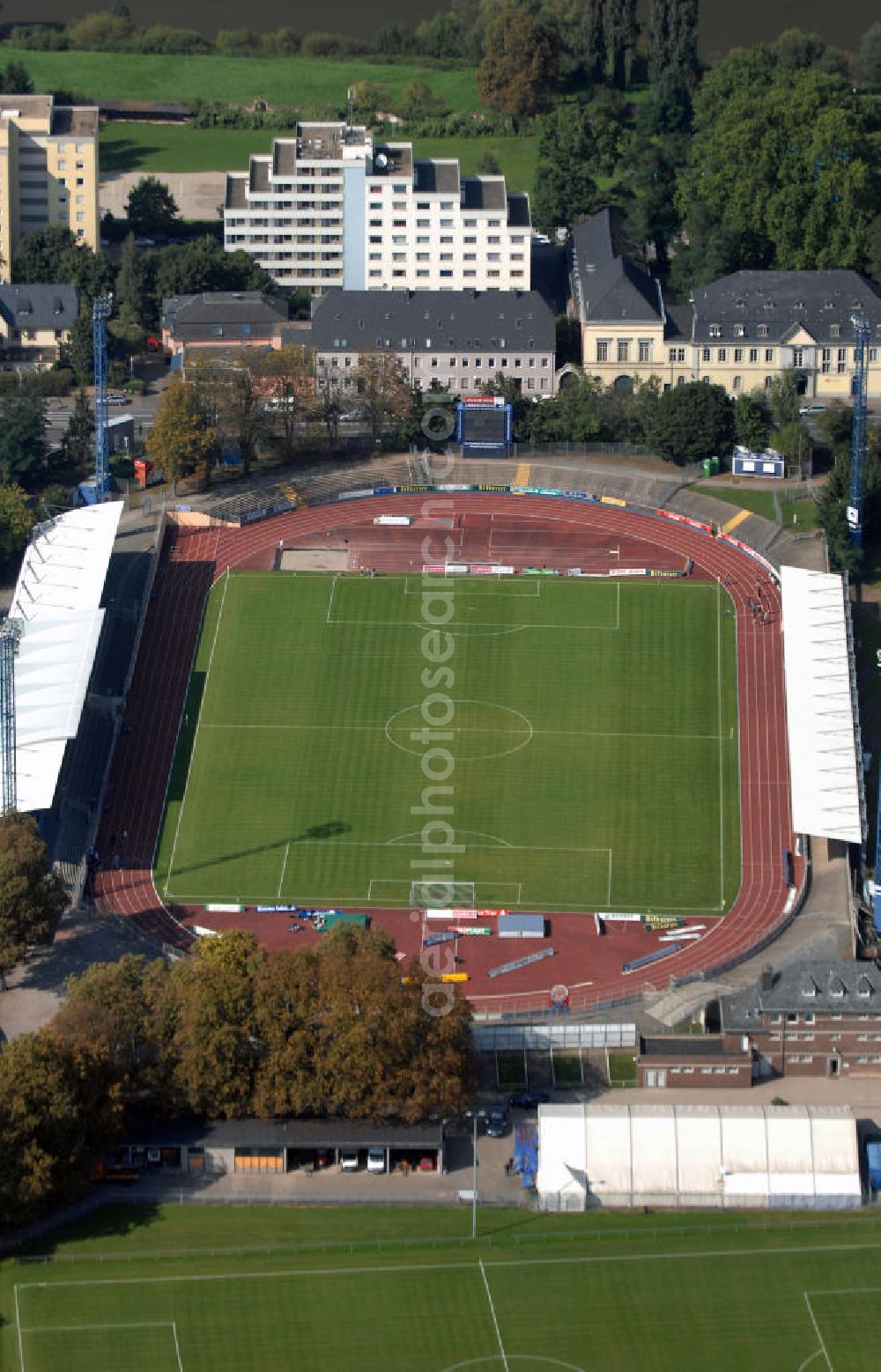 Trier from the bird's eye view: Blick auf die Sportanlage am Moselstadion. Das Moselstadion wurde 1930 gegründet, damals trug die Sportanlage noch den Namen Auf der D´ham. Auf Grund des FDB-Halbfinalspiels wurde 1998 eine Flutlichtanlage errichtet. Genutzt wird das Stadion vom SV Eintracht Trier, der in der Saison 2003/ 04 in die zweite Bundesliga aufstieg. Seitdem wurden einige Besserungsarbeiten am Stadion vorgenommen. Die Haupttribüne wurde erweitert und ein Vereinslokal errichtet was den Anstieg der Besucherzahlen zur Folge hatte. Inzwischen ist der SV Eintracht Trier wieder abgestiegen und weitere Umbaumaßnamen wurden vorerst auf Eis gelegt. Momentan bietet das Stadion Platz für 10.254 Zuschauer wovon 8000 Stehplätze, davon wiederrum 2000 überdacht sind. 2000 weitere Sitzplätze finden sich auf der Tribüne. Kontakt: SV Eintracht Trier, Am Stadion 1 54292 Trier, Tel. +49(0)651 1467 10, Fax +49(0)651 1467 171, Email: info@sv-eintracht-trier05.de